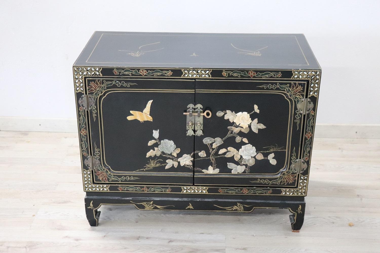 Early 20th century French beautiful small cabinet. Made of black lacquered wood, refined painted gold decoration. On each side, precious decoration with hand carved colored stones. On the doors and the sides flowers and birds. We advise you to look
