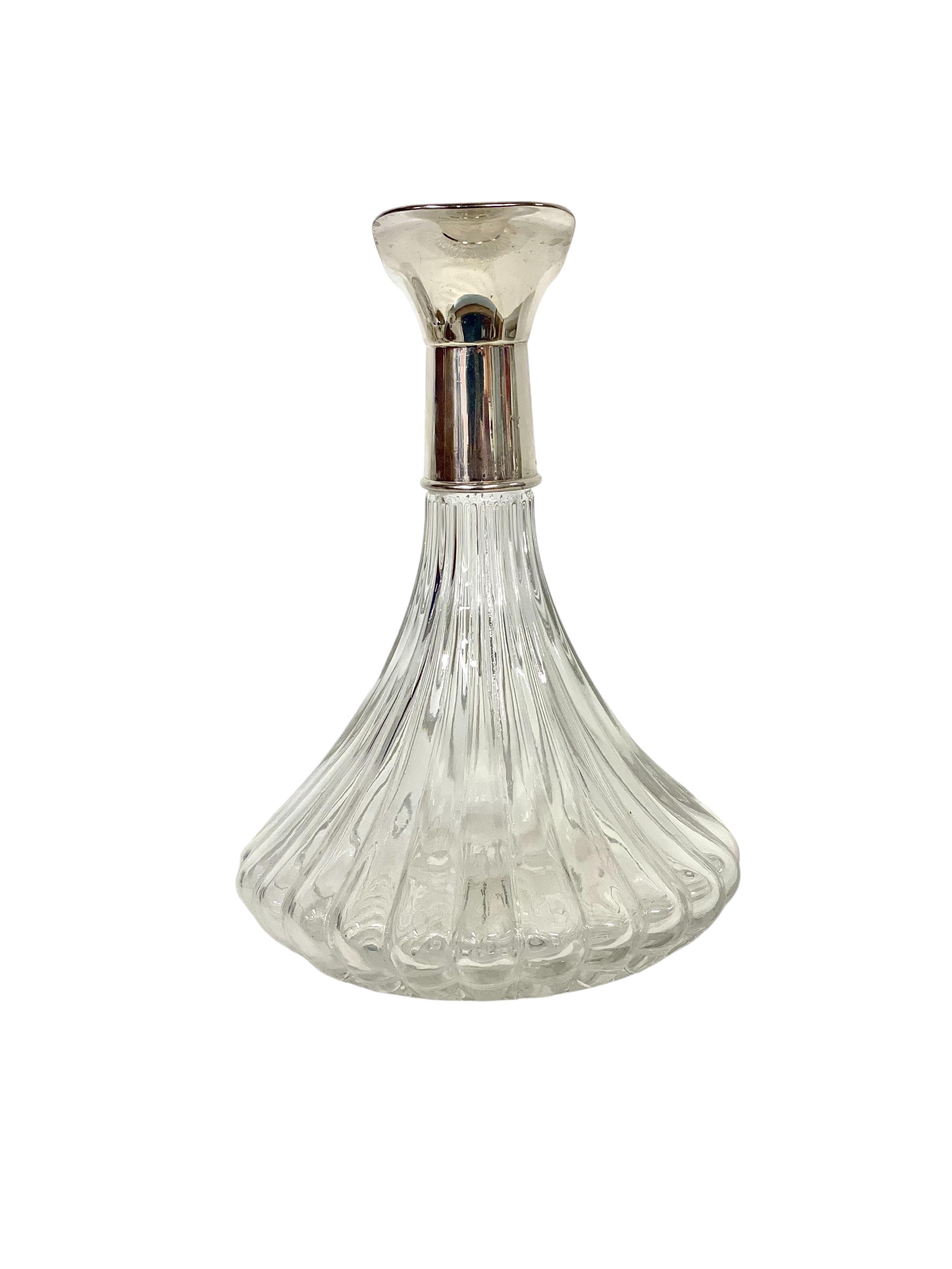 Este exquisito decantador vintage de Lancel Paris es un testimonio del diseño moderno de mediados de siglo. Fabricado con cristal estriado de alta calidad, el cuerpo del decantador presenta un hermoso juego de luces y sombras. El cuello plateado