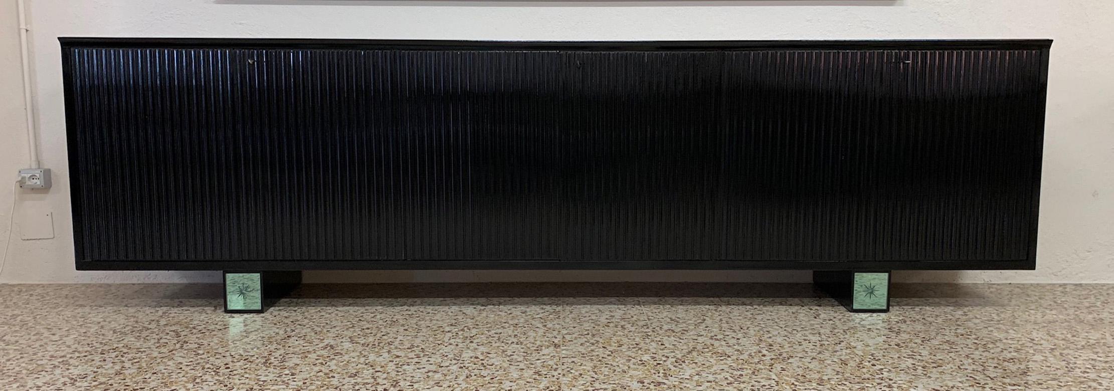 This rare art deco sideboard was produced in the late 1940s in cantù (Italy), probably on the design of Osvaldo Borsani.
It is completely black lacquered while the front of the legs is covered with two engraved and sandblasted mirrors representing