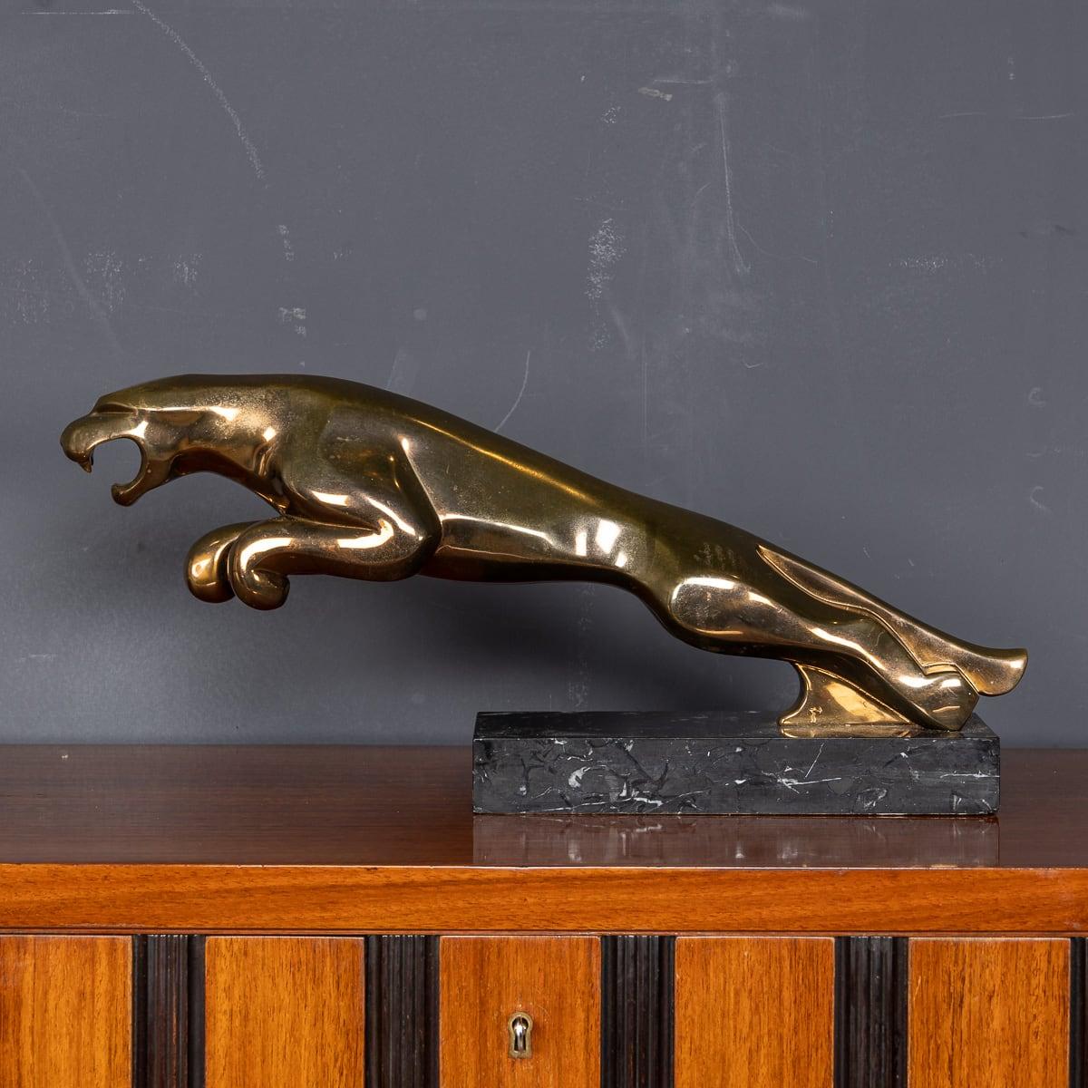 A 20th Century large bronze Jaguar mascot, gracefully leaping from a black and white marble base, once displayed at a prestigious jaguar car dealership Designed in the style of the iconic Jaguar automobile logo, this piece is a remarkable slice of