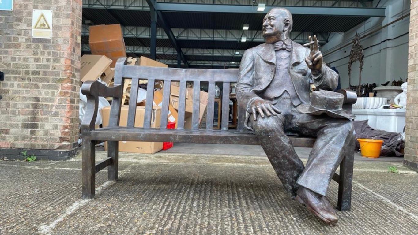 This is an stunning larger than a life-size vintage statue of the Prime Minister of the United Kingdom from 1940 to 1945, Winston Churchill, in a relaxed and informal way on an outdoor bench, dating from the second half of the 20th century. This
