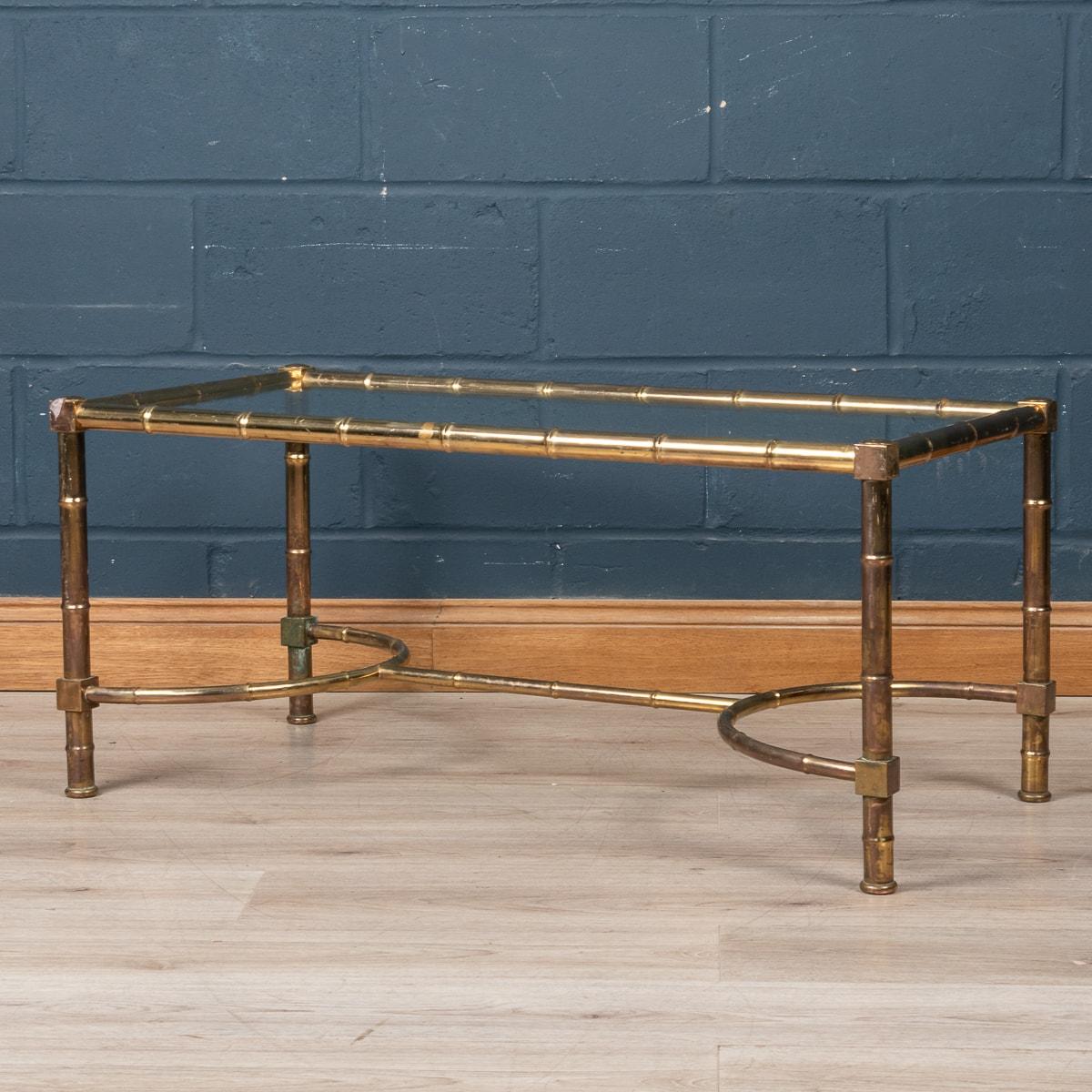 A large coffee table attributed to Maison Jansen, made in France around the 1970's. The faux bamboo frame made out of brass supporting a clear glass table top. A truly elegant solution for any interior looking to enrich the room with a little