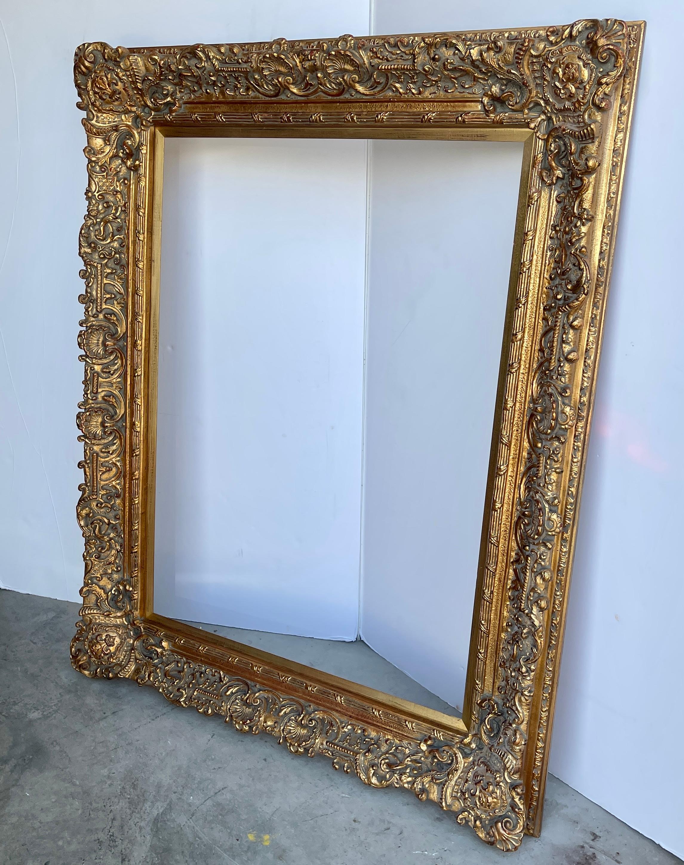 Large Ornate French Rococo Style Carved Ornate Gilt Wood Frame.

This gorgeous hand-crafted frame has lots of charming details including fleur de lis in the corners, shell motifs as well as other fantastic features. This substantial piece could be