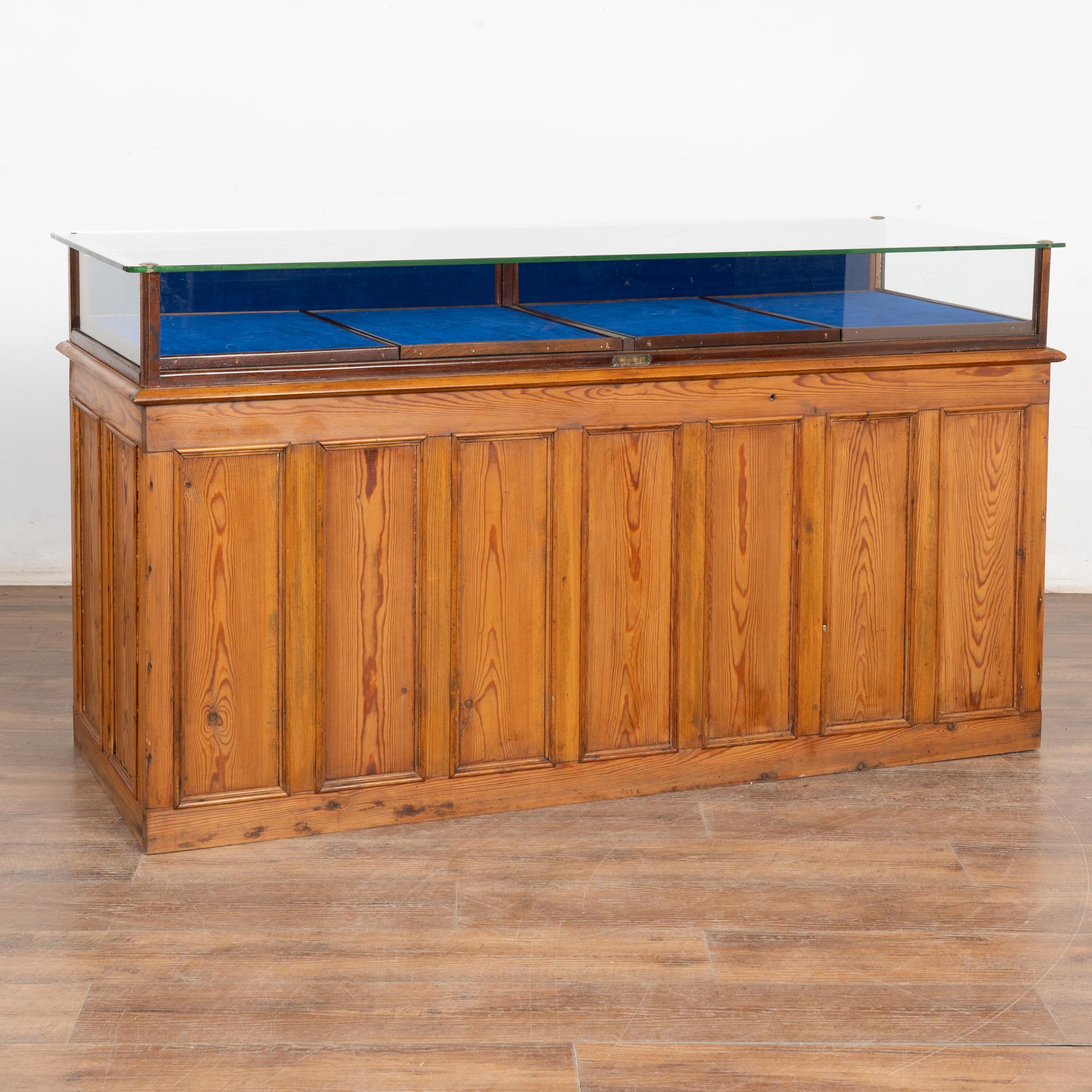 Diese große Vitrine besteht aus einem massiven Kiefernholzsockel, der von einer großen Glasvitrine gekrönt wird. Sie ist ideal für Schmuck, Uhren oder andere kleine Sammlerstücke.
Die Glasvitrine hat zwei unterteilte Ausstellungsbereiche, die mit