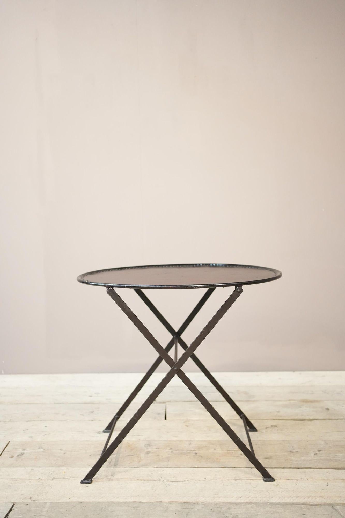 This is a fabulous piece of 20th century design inspired by the 19th century campaign furniture that would pack away for ease of carrying. This is a leather and metal folding drinks table. It is a smart design that will sit well in a huge number of