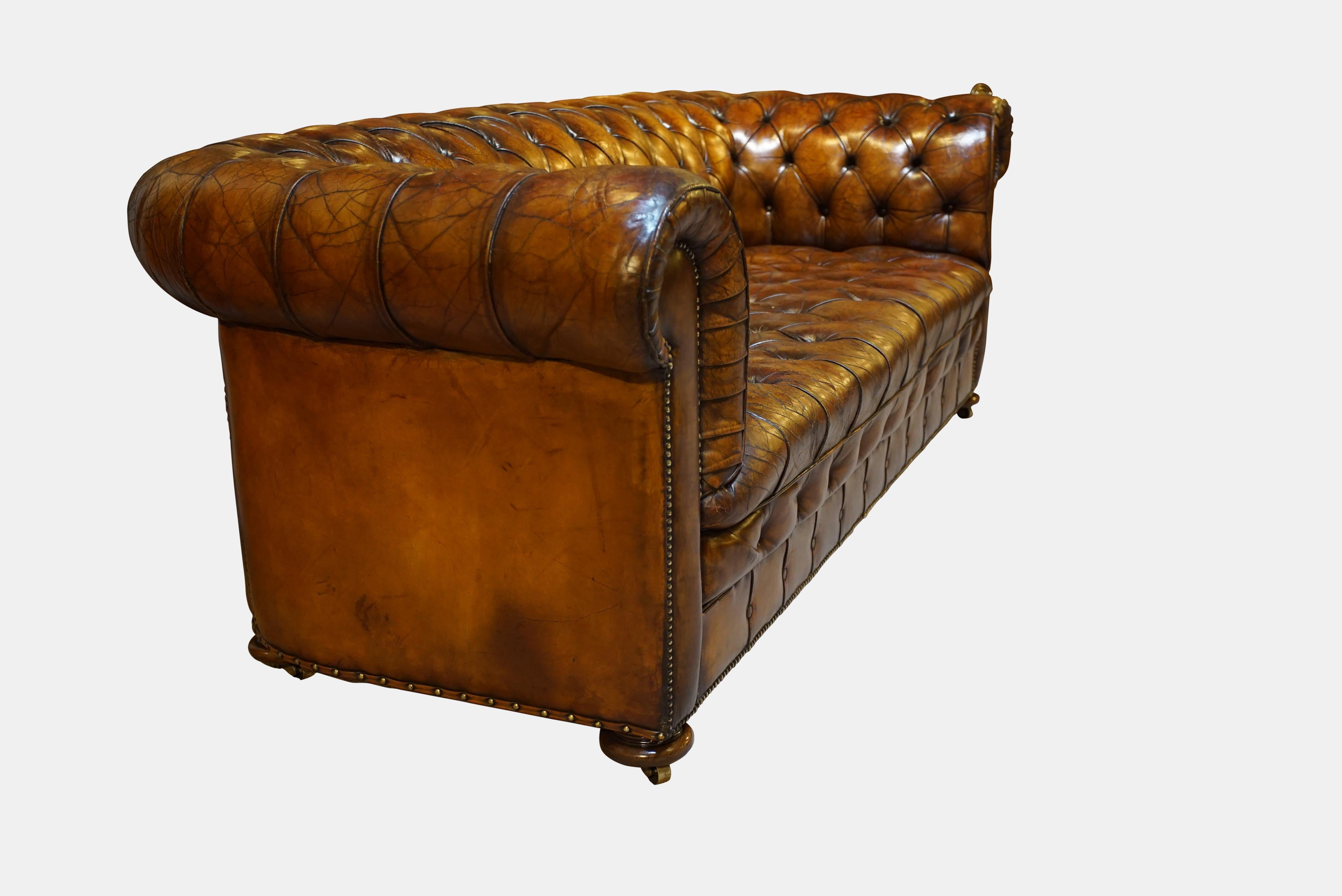 A good vintage 20th century leather and buttoned chesterfield, of a rich chestnut colour with rolled and pleated arms on turned bun feet and castors,

circa 1930.