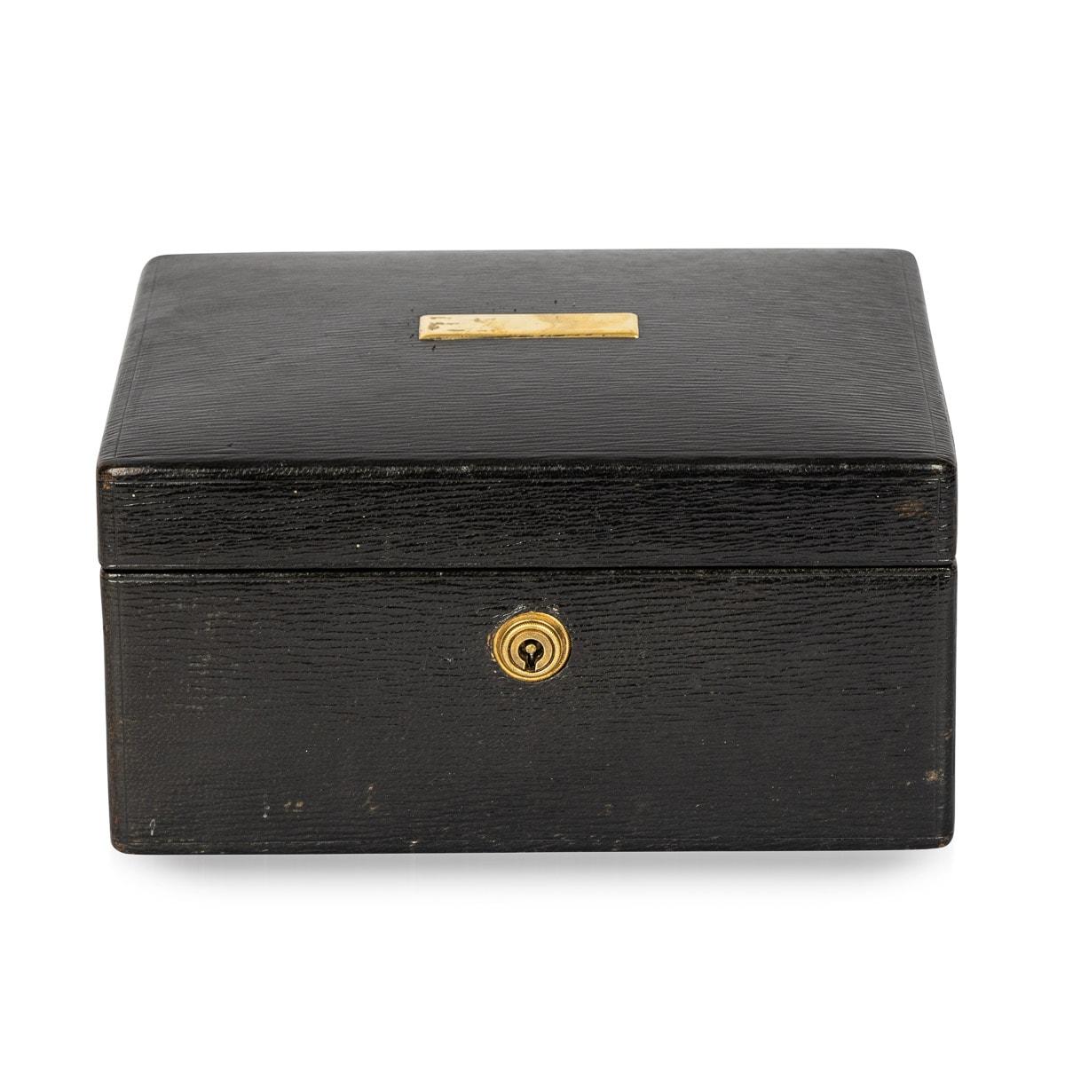 Antique early 20th Century leather bound jewellery box. This charming box features a brass plaque and a round escutcheon plate. The interior includes two removable velvet lined trays which have partitions to store an assortment of jewellery. The box