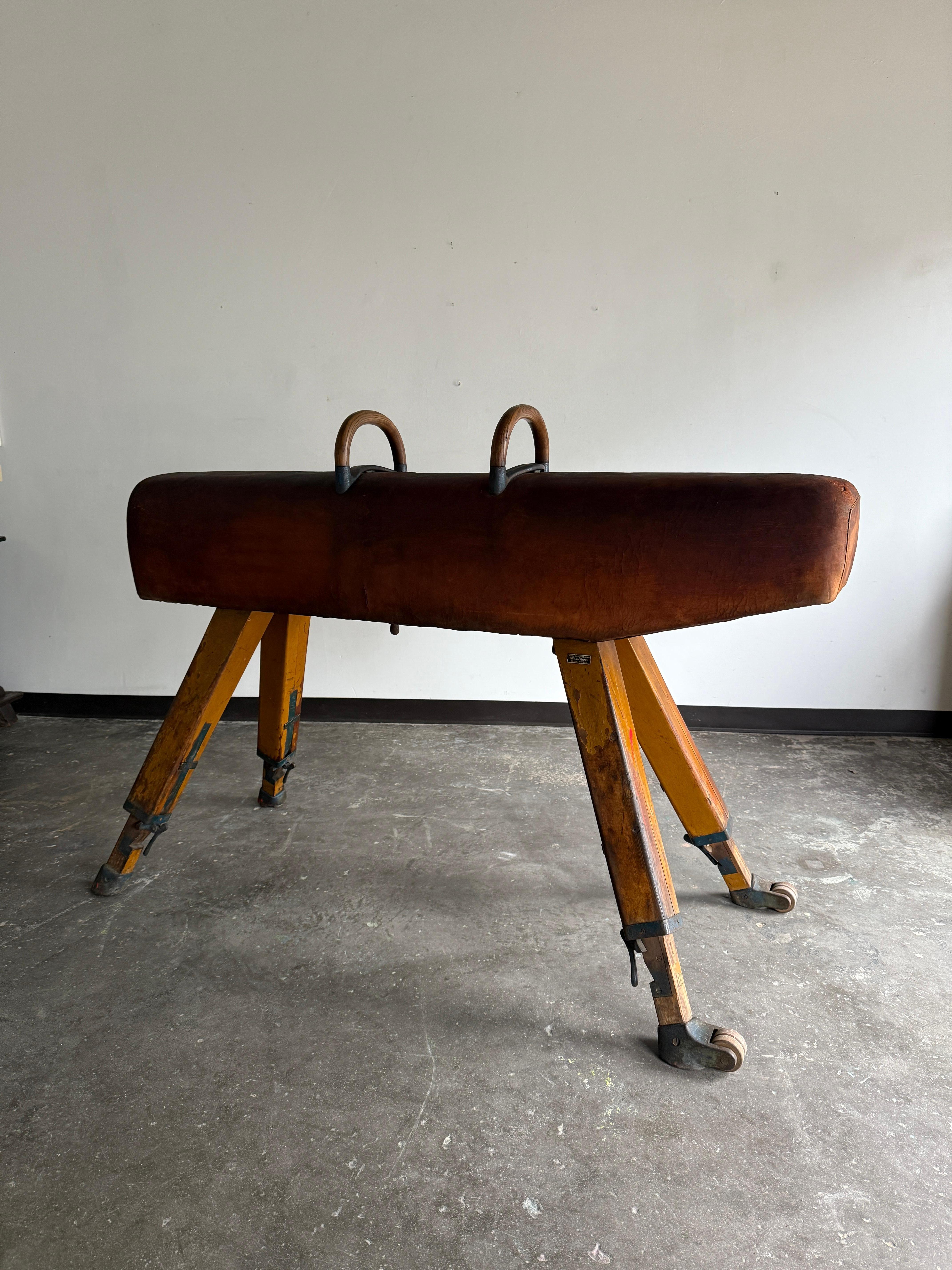 Leather pommel horse by Wilh. Holbeck Essen-Werden (see label). In excellent vintage condition with age-consistent patina and character. height is adjustable. Pommel can be styled in a variety of ways from displaying gorgeous tapestries to serving
