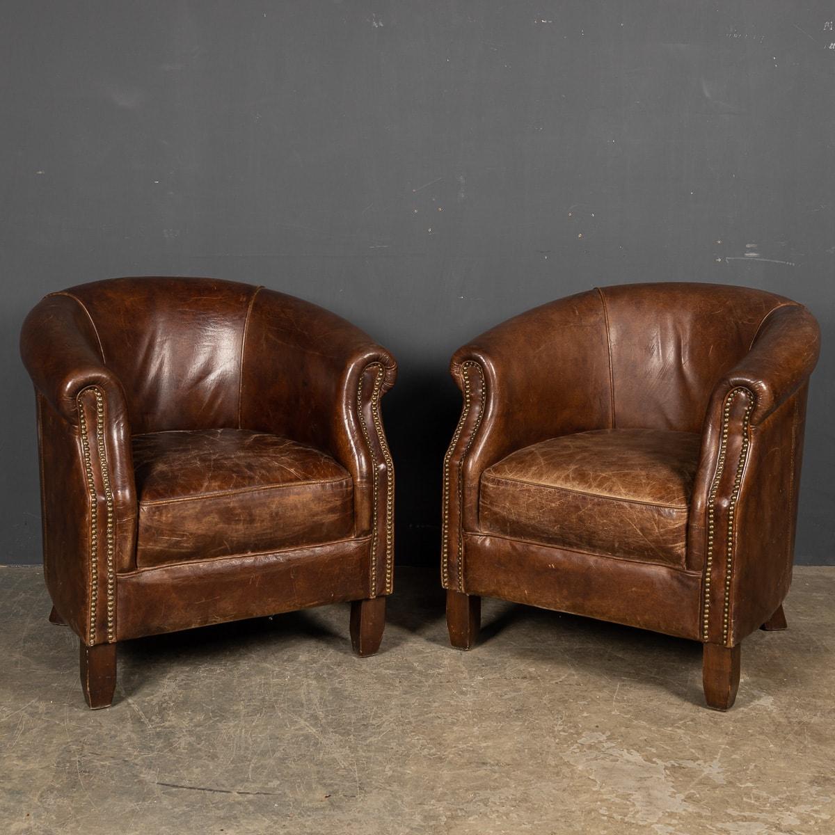 Showing superb patina and colour, this wonderful pair of tub chairs were hand upholstered leather with brass stud detail in Holland by the finest craftsmen in the latter part of the 20th century. 

CONDITION
In Good Condition - Some wear consistent