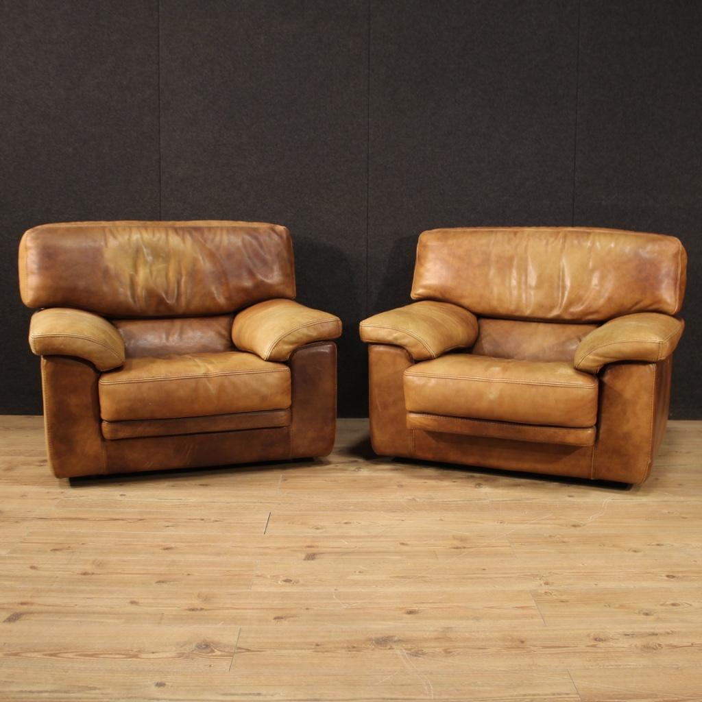 Pair of French armchairs from the 1970s-1980s. Furniture covered in leather in beautiful patina with various signs of wear. Fabulously decored armchairs ideal for use in a living room or studio, with excellent comfort, measures: seat height of 42