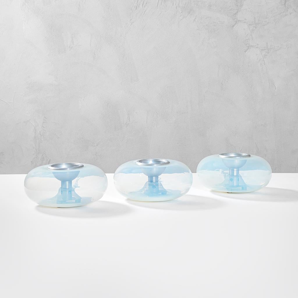 Set of three Table Lamps designed by Leucos in '70s. Each lamp has the structure in Chromed Metal and the diffuser is in Murano Glass, colored in transparent blue, that make a special effect once switched on.
Presence of the brandmark 