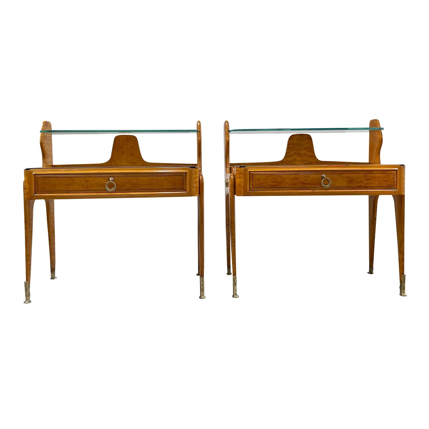 A vintage Mid-Century modern Italian pair of nightstands with a slim smoked glass top, made of hand crafted polished, partly veneered Maplewood, designed by Paolo Buffa in good condition. Each of the polished bed side tables are composed with a