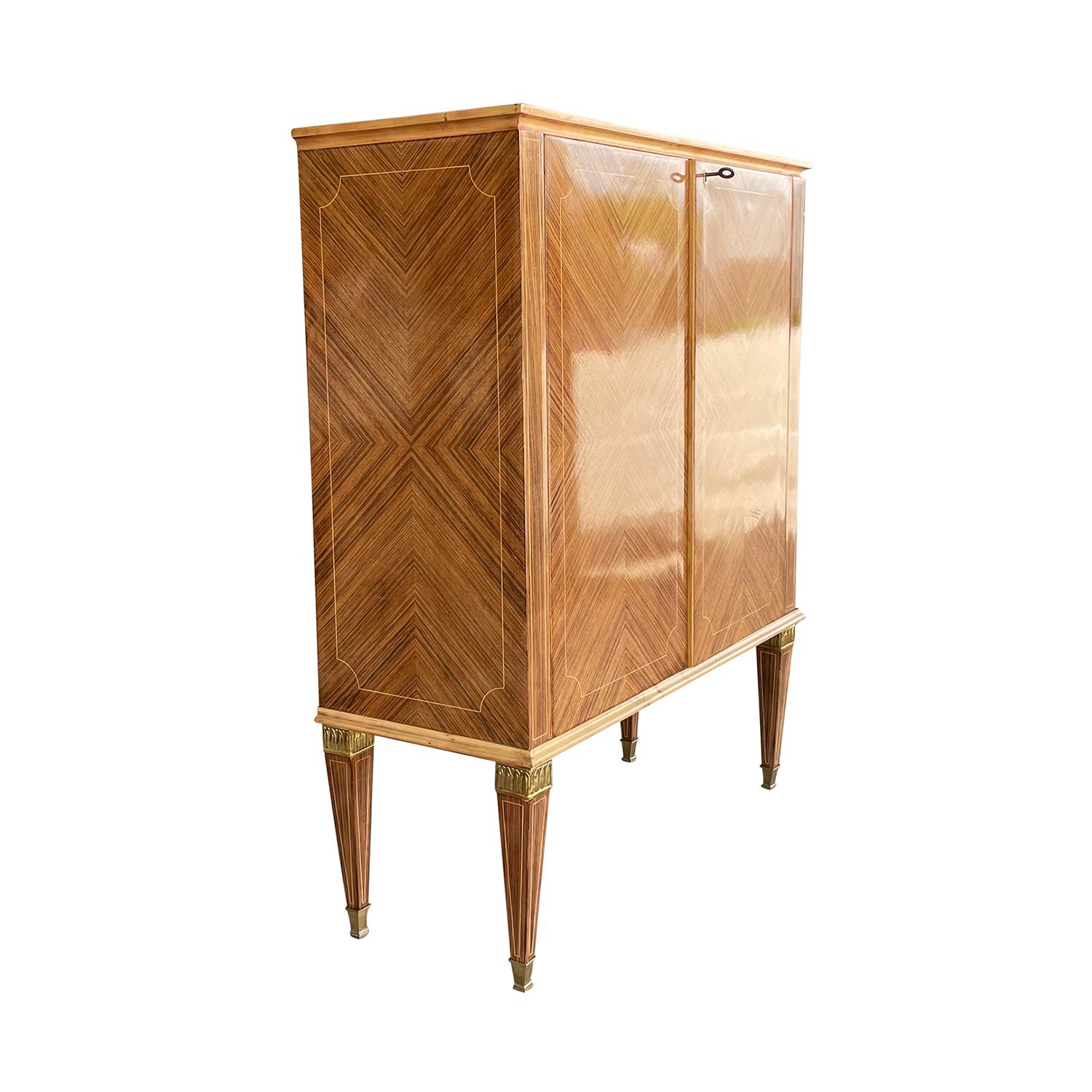 A light-brown, vintage Mid-Century Modern Italian cabinet made of hand carved polished Walnut with two doors and two shelves, designed by Paolo Buffa in good condition. The small cupboard features its original brass hardware and keys with four