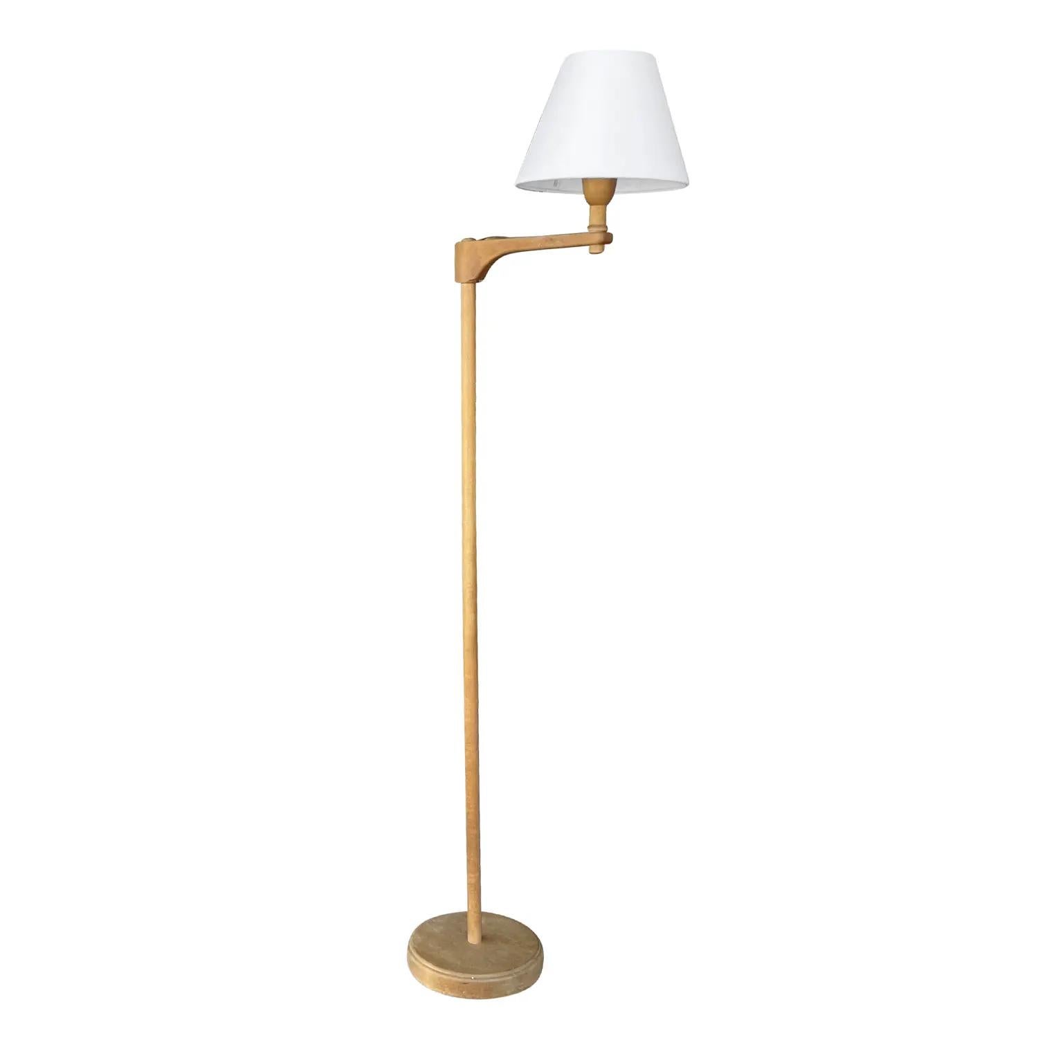 A light-brown, antique Swedish Gustavian Staken, floor lamp made of hand crafted Walnut, designed by Carl Malmsten in good condition. The Scandinavian reading lamp is composed with a new small round white shade attached to a flexible, adjustable