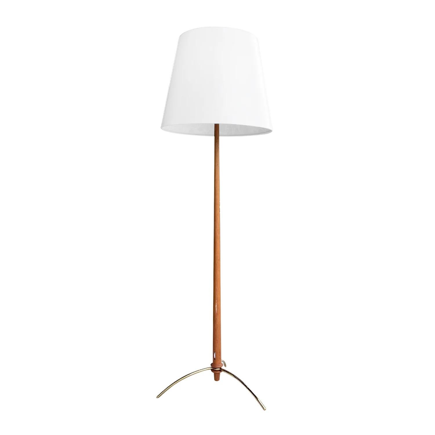 A light-brown, vintage Mid-Century Modern Swedish floor lamp made of hand crafted Teakwood, composed with its original light switch and a new white round shade, designed by Hans-Agne Jakobsson in good condition. The stem of the Scandinavian lighting