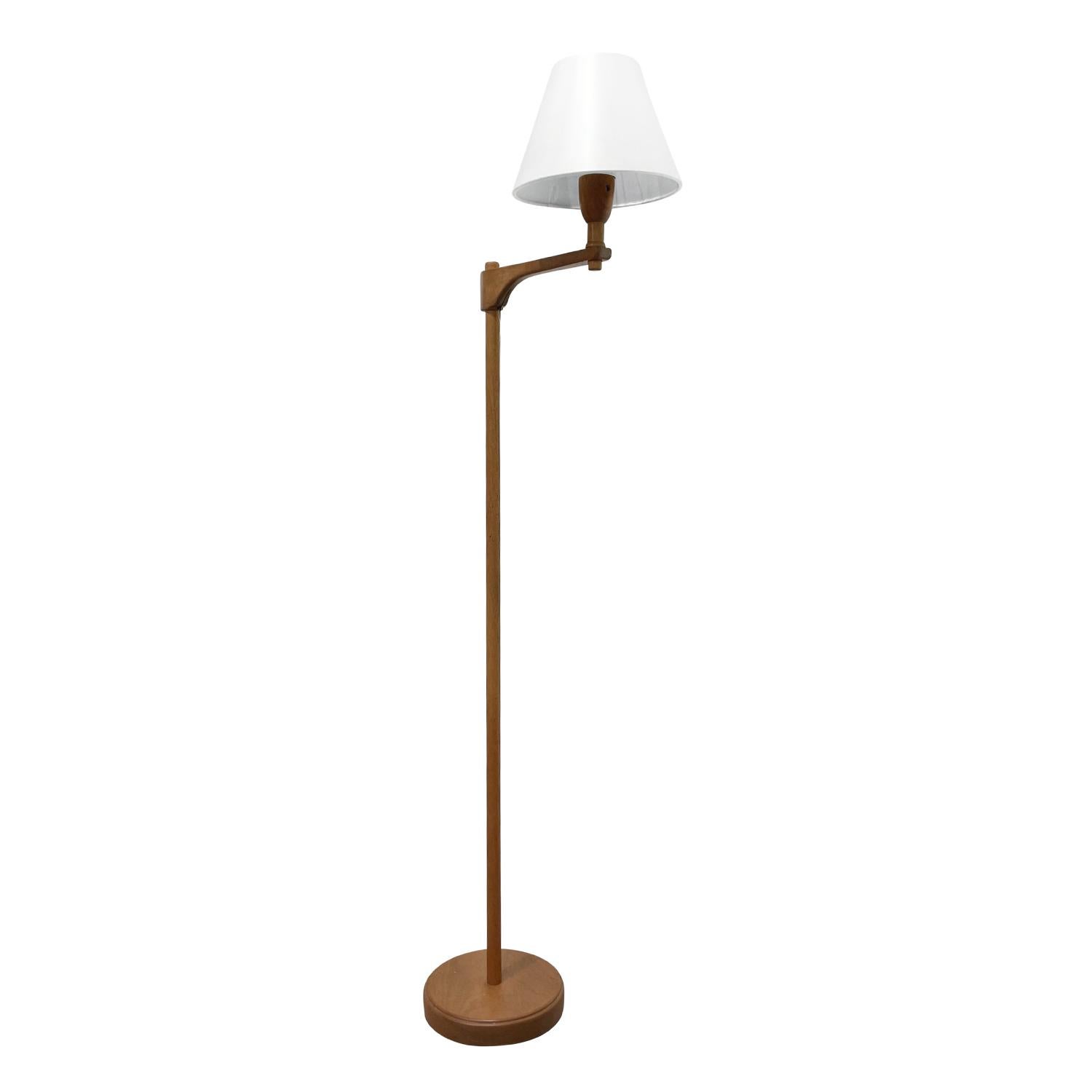 A light-brown, antique Swedish Gustavian Staken, floor lamp made of hand carved teak wood, designed by Carl Malmsten in good condition. The Scandinavian reading lamp is composed with a new small round white shade attached to a flexible, adjustable