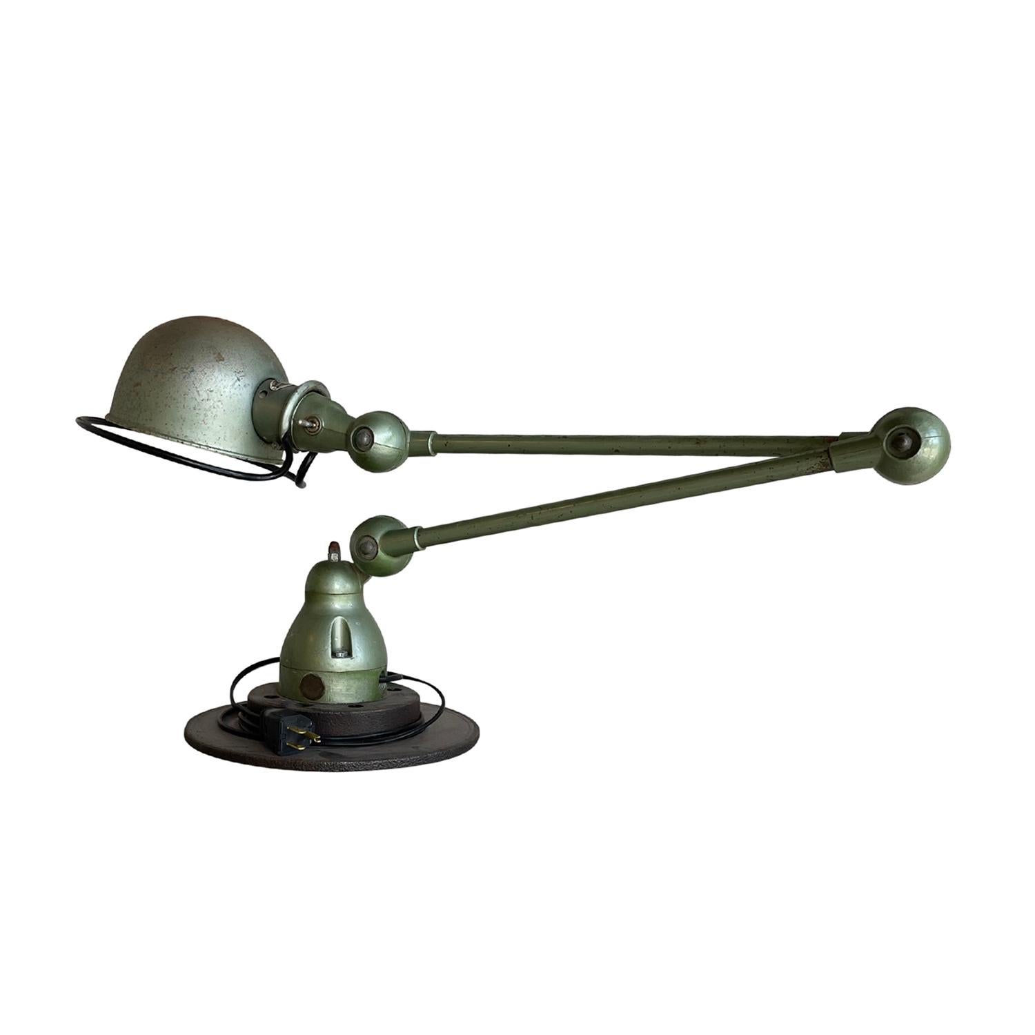 A light-green, vintage Mid-Century Modern French desk light made of hand crafted metal, designed by Jean Louis Domecq and produced by Jielde, in good condition. The Industrial car brake, table lamp is composed with two adjustable arms, featuring a