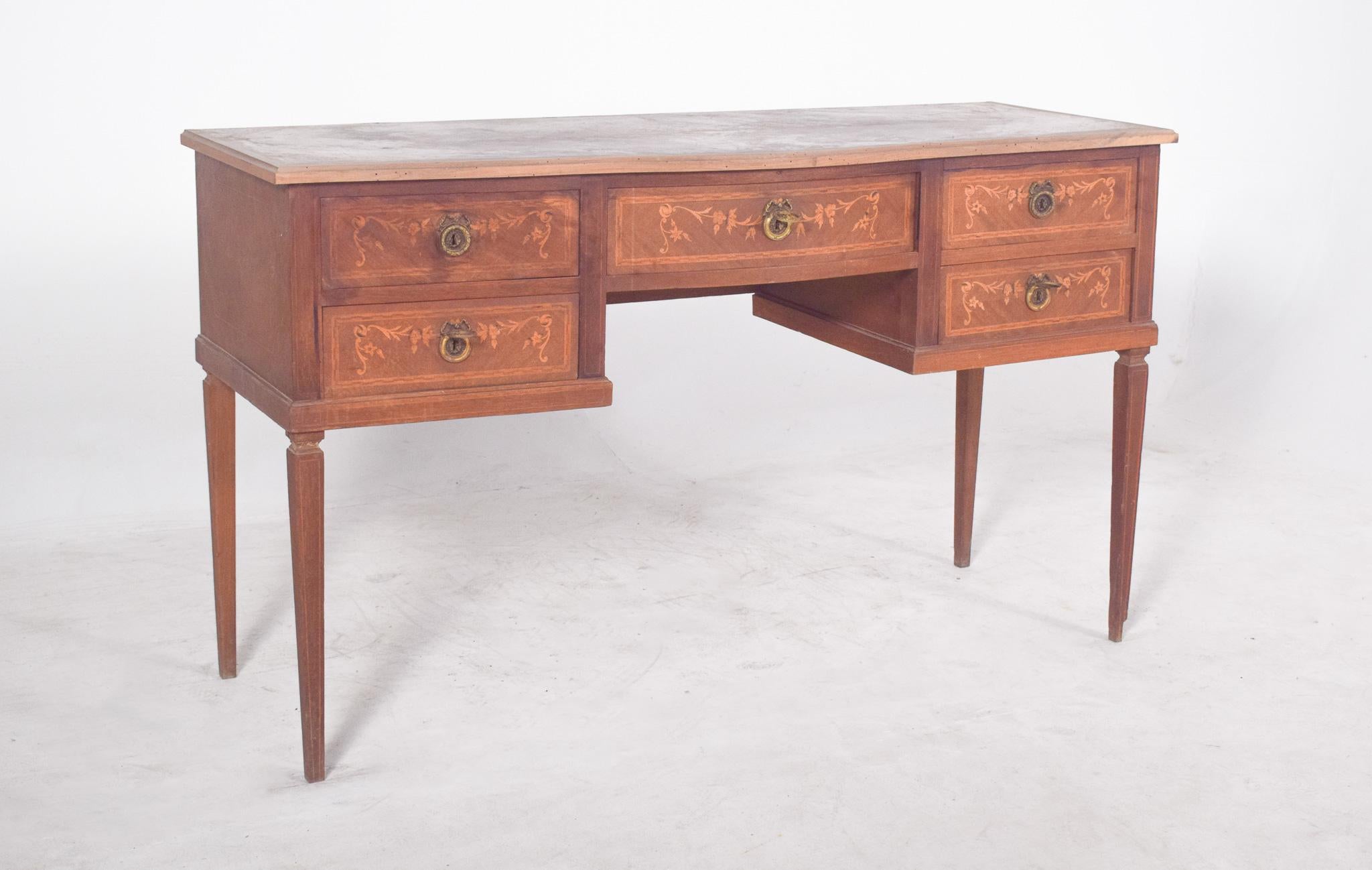 Light wood dressing table with marquetry. This piece stands out for its symmetry and the careful craftsmanship of the marquetry. With five drawers, two on each side and a slightly larger central one, decorated with floral motifs delicately inlaid