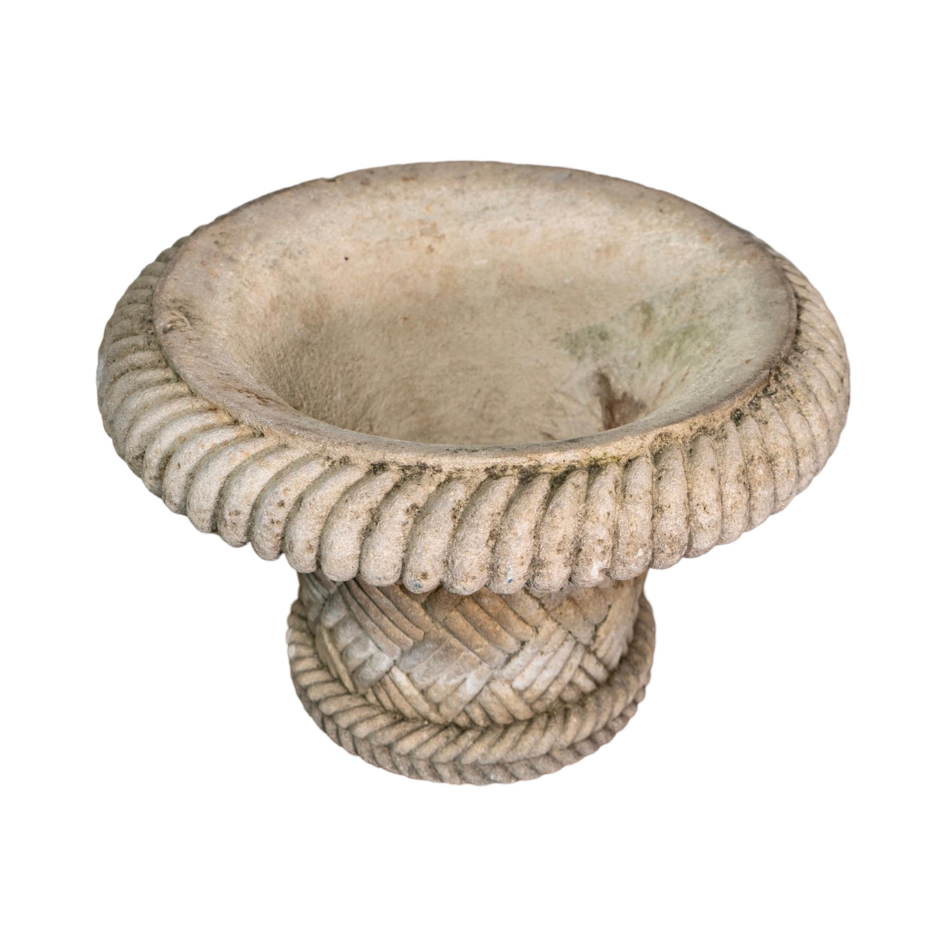This circa 1980s French Limestone Planter showcases a classic basket weave carved design, adding charm and character to any outdoor space. Handcrafted in France, each planter is unique and features its own distinct wear. Made from durable limestone,