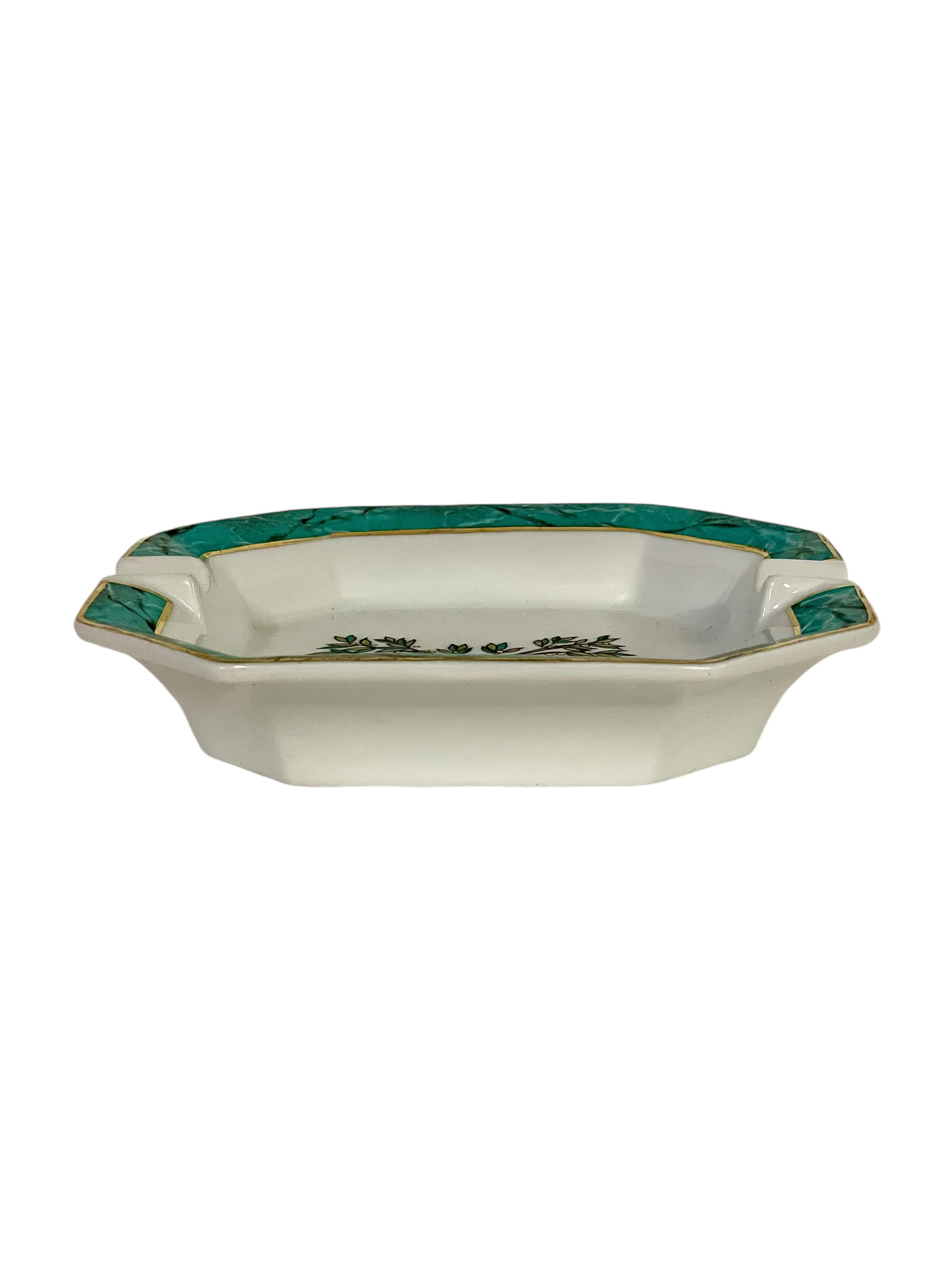 Esta elegante baratija (o cenicero) de porcelana de Limoges, procedente del prestigioso Hôtel de Crillon de París, presenta un bello diseño policromado. Pintado a mano con gran atención al detalle, muestra un refinado motivo de ramas de laurel