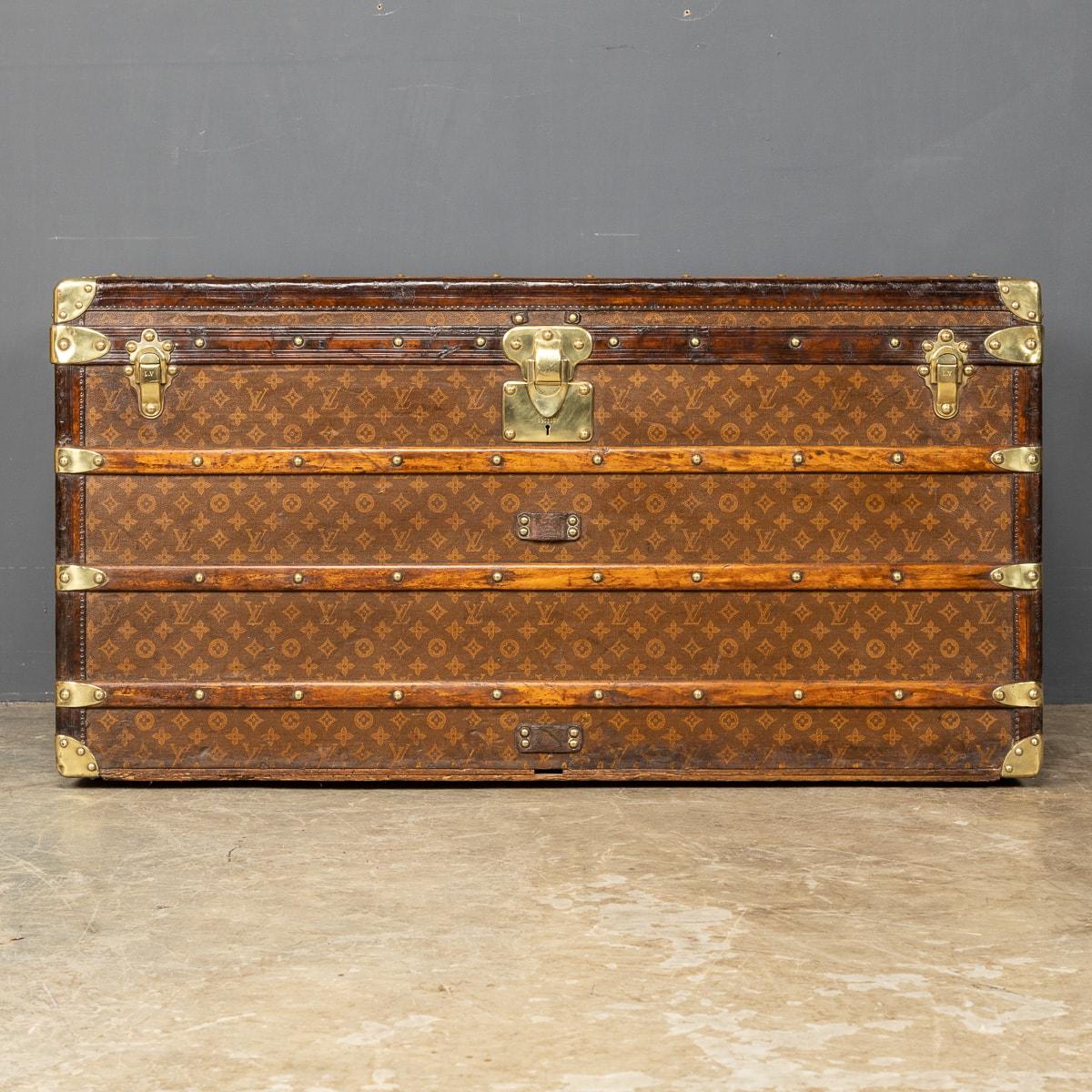 Antique 20th Century large monogramed canvas trunk from Louis Vuitton lined in ecru calico with two full width trays. The handles and fittings are all original brass.
Around the turn of the 19th and 20th century Louis Vuitton had established himself