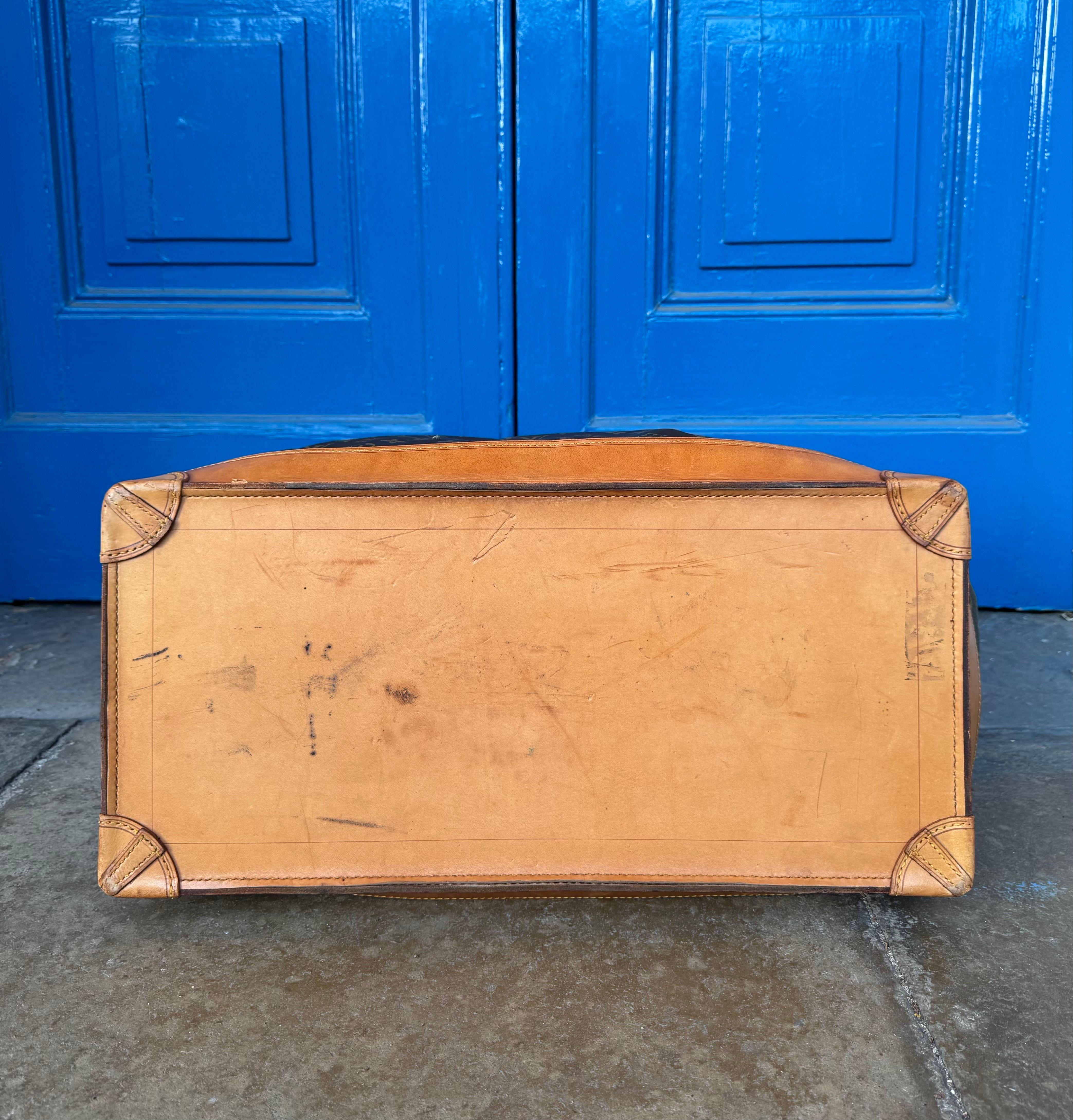 La deuxième plus grande variante du sac steamer produit par Louis Vuitton mesure 55 cm. Orné de la toile emblématique du monogramme, ce bagage est non seulement remarquable par sa taille, mais aussi par son état. Il date des années 1990 et reste