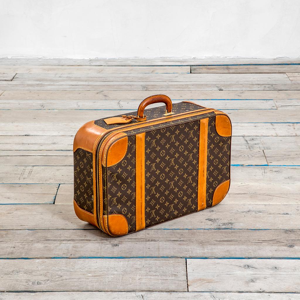 Timeless suitcase by Louis Vuitton from the 60s with rounded edges and a double zipper. It is easy to carry with its comfortable rounded handles and bears a removable ID holder. It is entirely in leather with the classic Monogram Canvas. Original