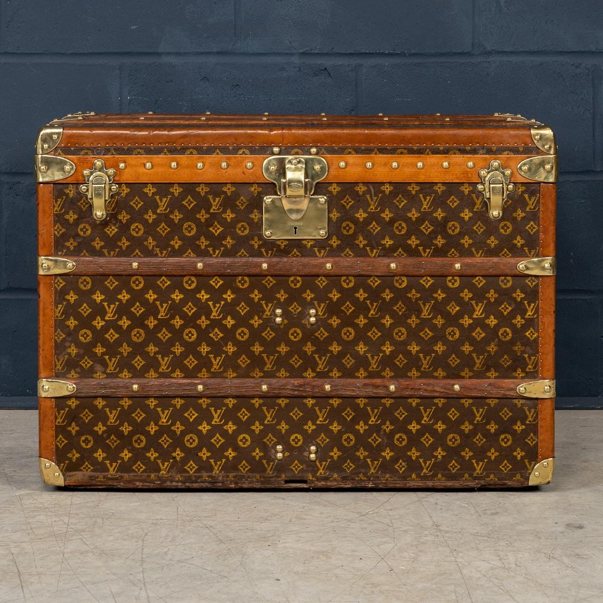 Ein Louis Vuitton-Koffer aus dem frühen 20. Jahrhundert. Der Koffer, ein unverzichtbarer Gegenstand für die Elite der Reisenden seiner Zeit, ist mit dem kultigen LV-Monogramm aus Segeltuch verziert, das von Lousine-Besätzen und Messingbeschlägen