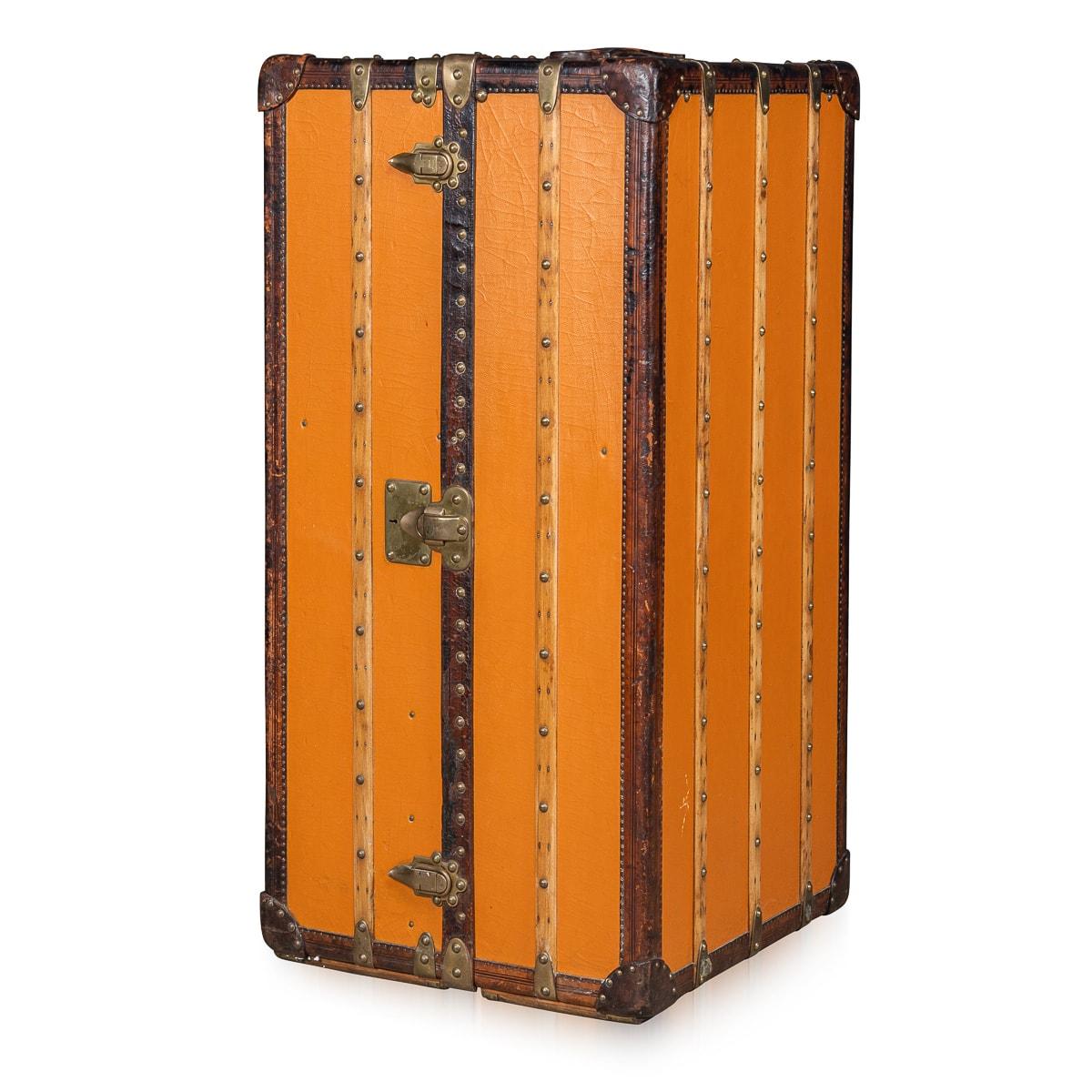 Treten Sie ein in das Reich des Vintage-Luxus mit dieser außergewöhnlich seltenen Garderobentruhe von Louis Vuitton, die aus dem frühen 20. Jahrhundert stammt, etwa 1900-1910. Dieser vertikale Koffer aus dem charakteristischen orangefarbenen