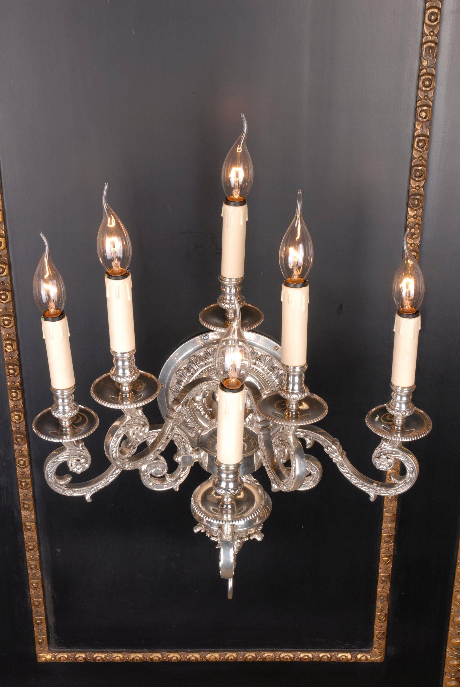 Baroque wall light in Louis XIV style.
Six flamed light corpus. Polished and engraved bronze. Round, reliefed, wall-shield. There from, six light arms composed of spirals.

(F-Ra-71).