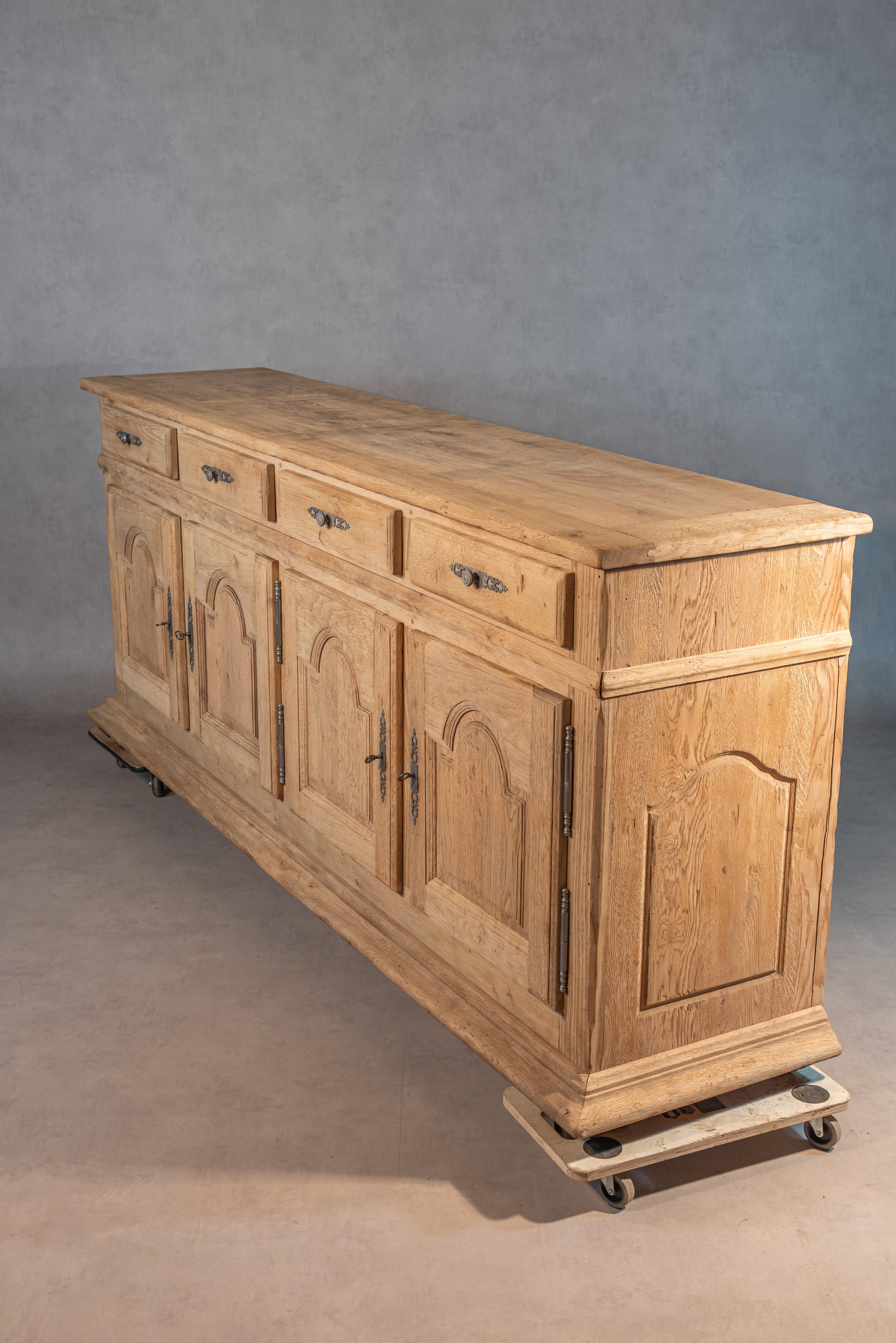 This 20th Century Louis XIV French Bleached Oak Enfilade is a remarkable piece of furniture that showcases exceptional quality and craftsmanship. The enfilade has been professionally cleaned, sanded, and bleached to reveal its beautiful and pure