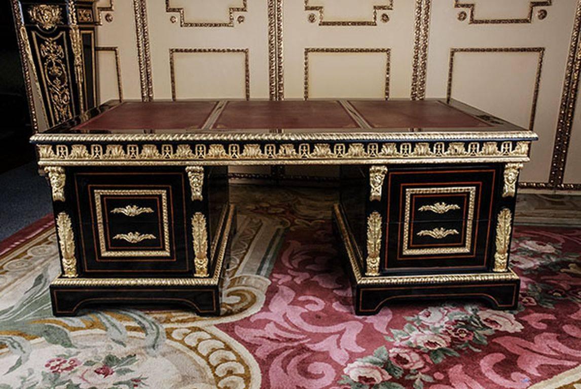 Imposing French writing table in style of Louis XIV.
Piano black polished veneer on solid pinewood. Three part, straight border. Narrow overlapping, wide framed writing plate, middle laid, gold embossed leather surface. Underneath, three drawers of