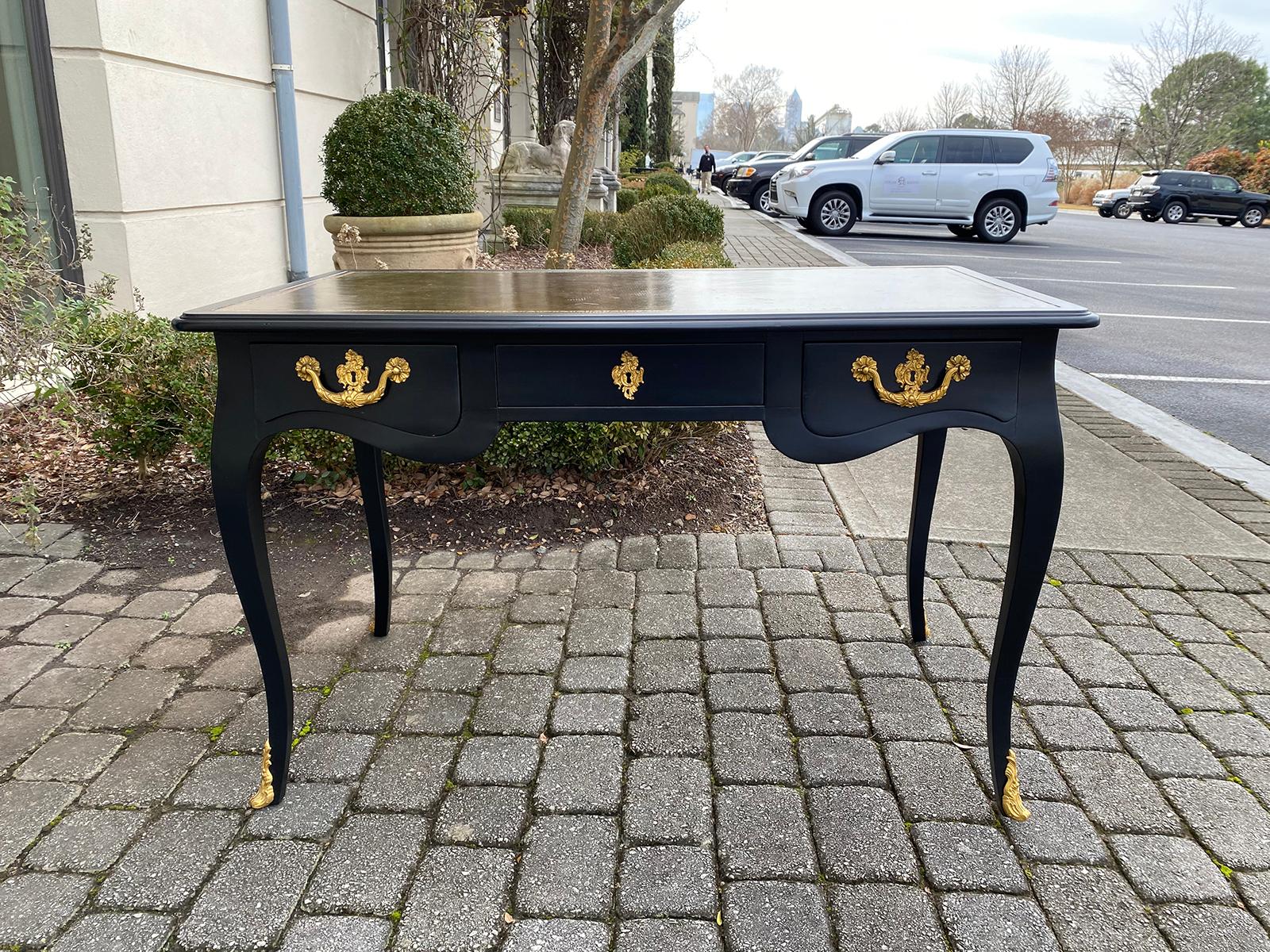 20th century Louis XV style black lacquered leather top bureau plat desk. Three drawers, two writing slides, and gilt bronze ormolu hardware. 1 key.
Measure: Apron is 24