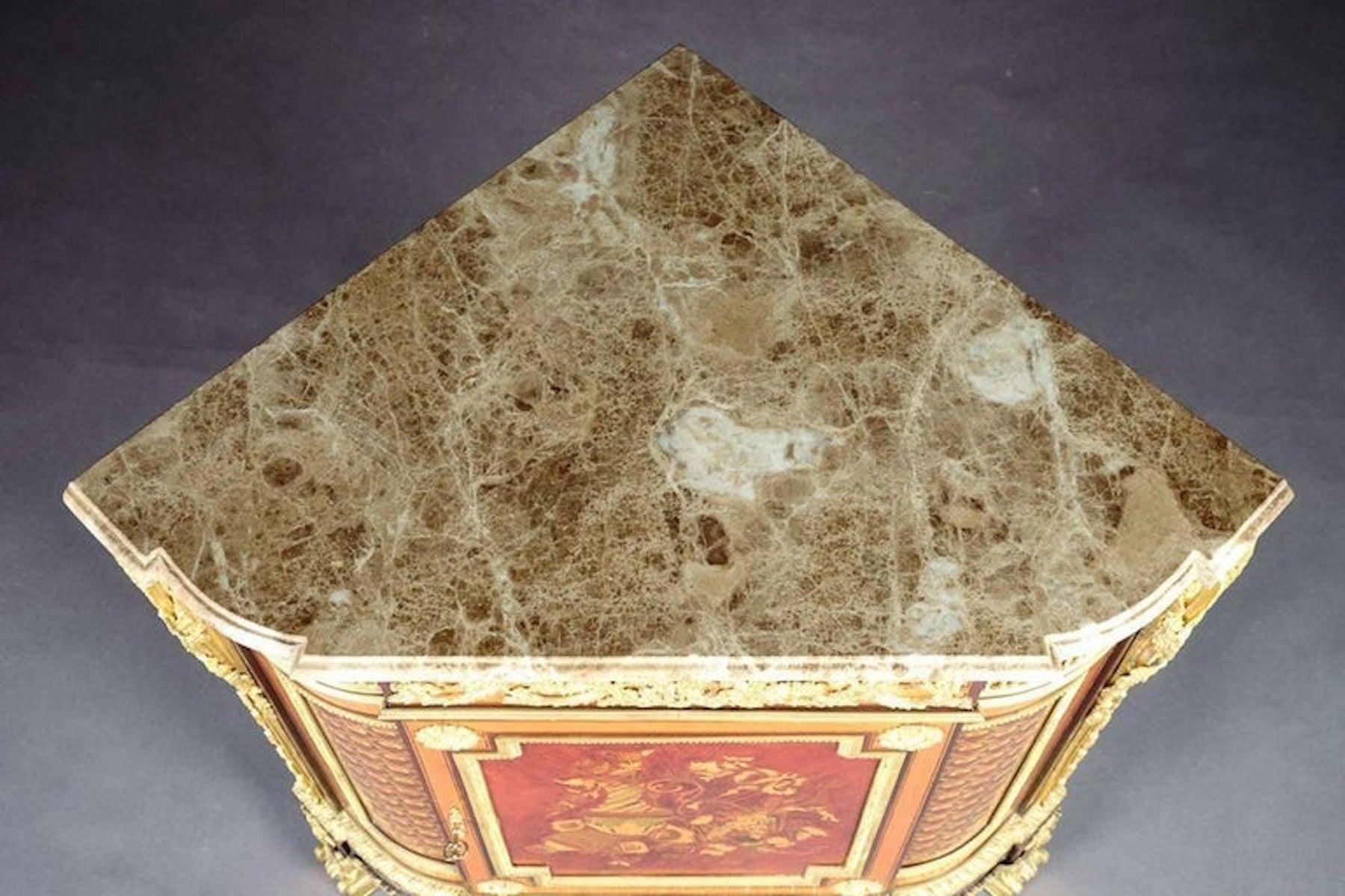 Bronze of exceptional quality. Marble panel, over frieze drawer and a large barrier door flanked by corner fittings with acanthus volutes and garlands, with amaranth, bergahorn and colorful fruitwood inlay front and sides with flower head trellis