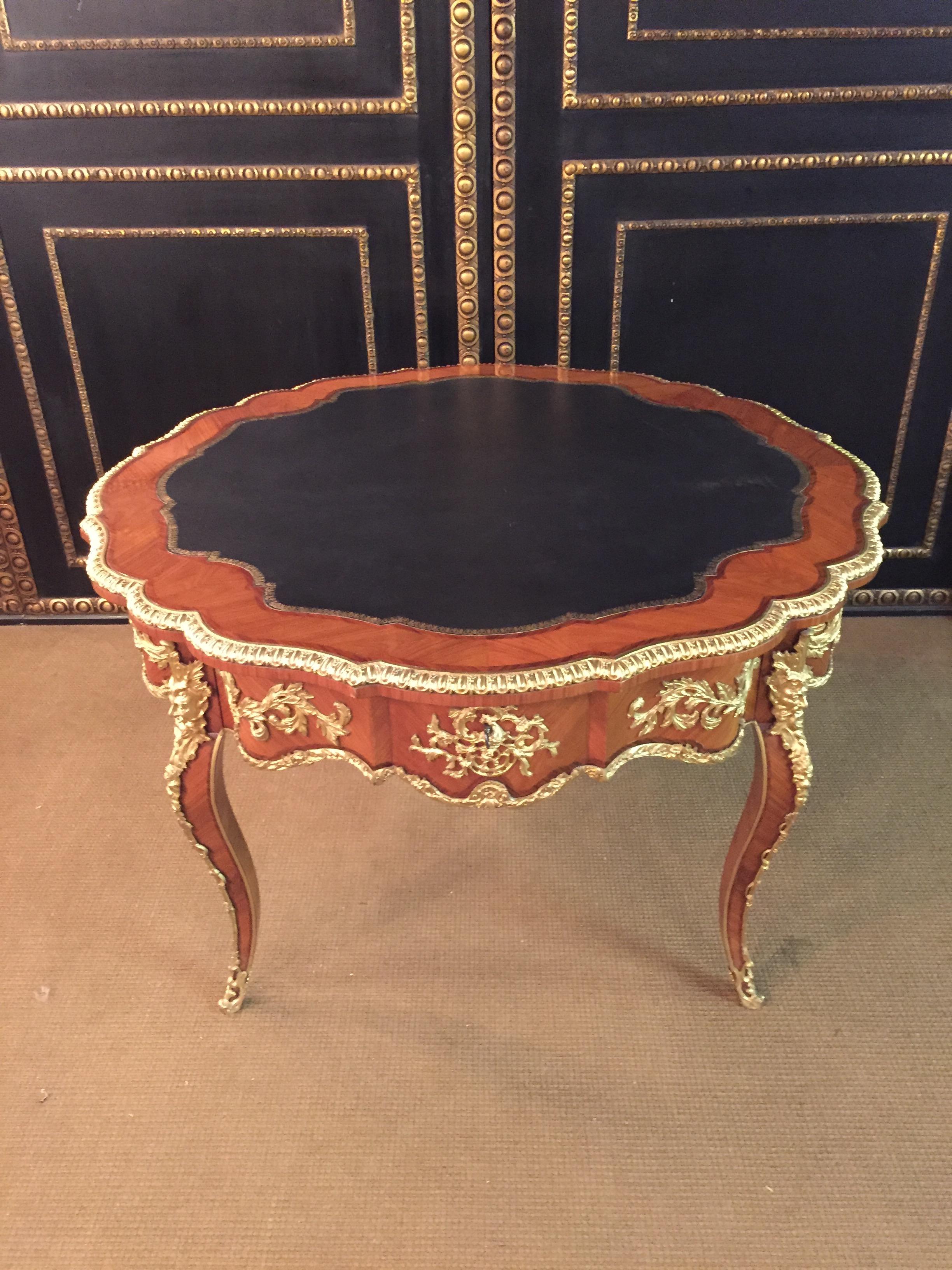 Majestic French salon table in Louis XV style. Polished veneer on solid pinewood. Exceptionally finest engraved, decorative broken rocailles, inlaid with acanthus, and flowered details. On two forward looking imposing bearded devils masks on curved