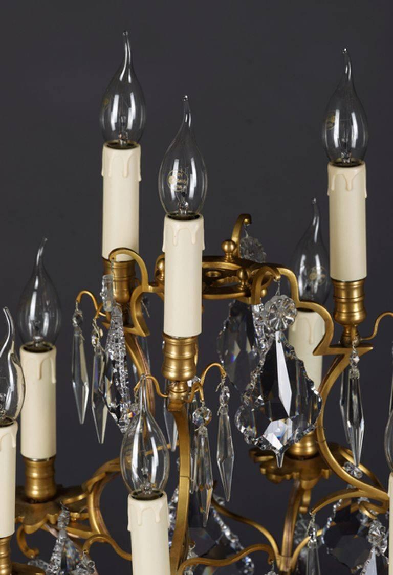 Exclusive Girandole in the Louis Quinze style.
Brass, chiseled. On three-legged curved plinth with three flared feet with garland trim.
High baluster-shaped body. Outgoing nine passively flared luminaries. In three further graded levels bent