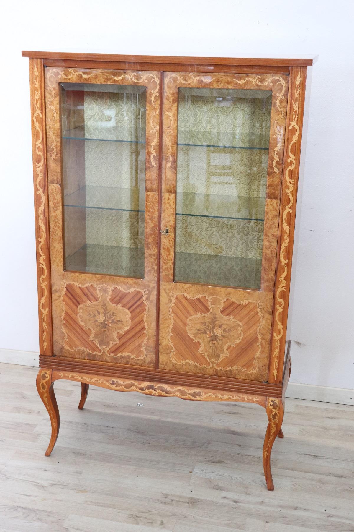 Elegant Italian vitrine in Louis XV style. Characterized by a refined inlay work with many different precious woods. Floral taste decoration. Interior lined with elegant fabric. This vitrine is perfect for displaying your precious objects. Excellent