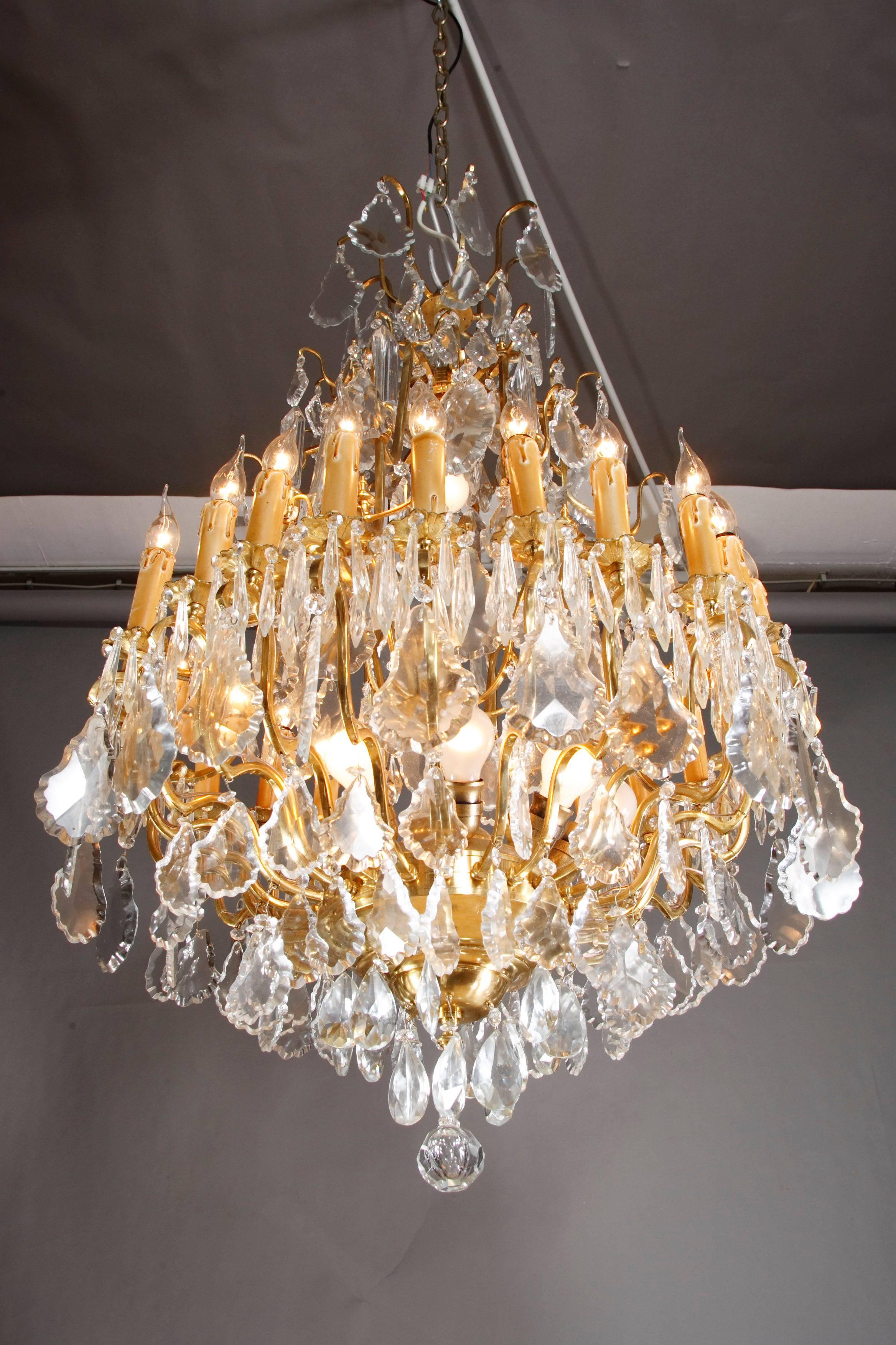 Lampadario francese a prismi in stile Luigi XV.
Ottone lucido. Cristallo finemente macinato. Ventiquattro bracci luminosi curvi.

(F-Hud-2).