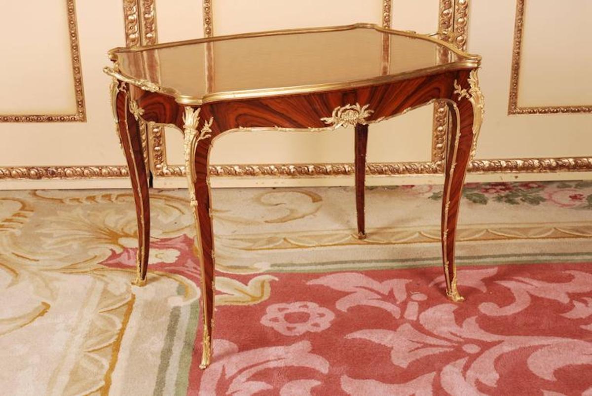 solid beech, lightly curved convex and concave body, flanked by out-standing pilaster strips on high legs, below a sweeping border, with brass framework and fixtures ending in sabots. Broken-through Rocaille applications and cartouche formed
