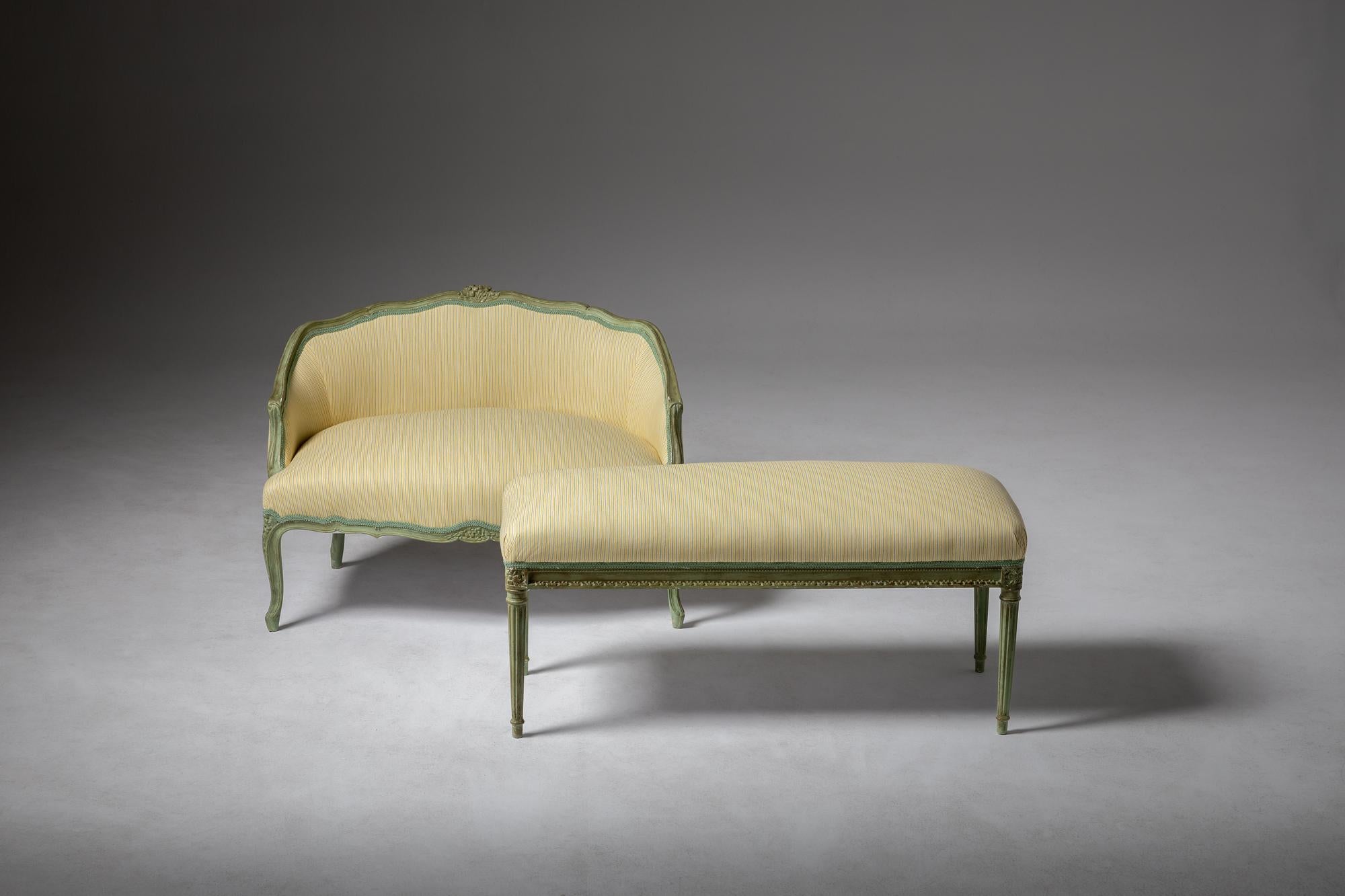Cet ensemble composé d'un canapé et d'un tabouret de style Louis XV, peint en vert et originaire d'Europe au milieu du XXe siècle, reflète l'élégance et le raffinement de la période rococo, adaptés aux goûts contemporains du XXe siècle. Il possède