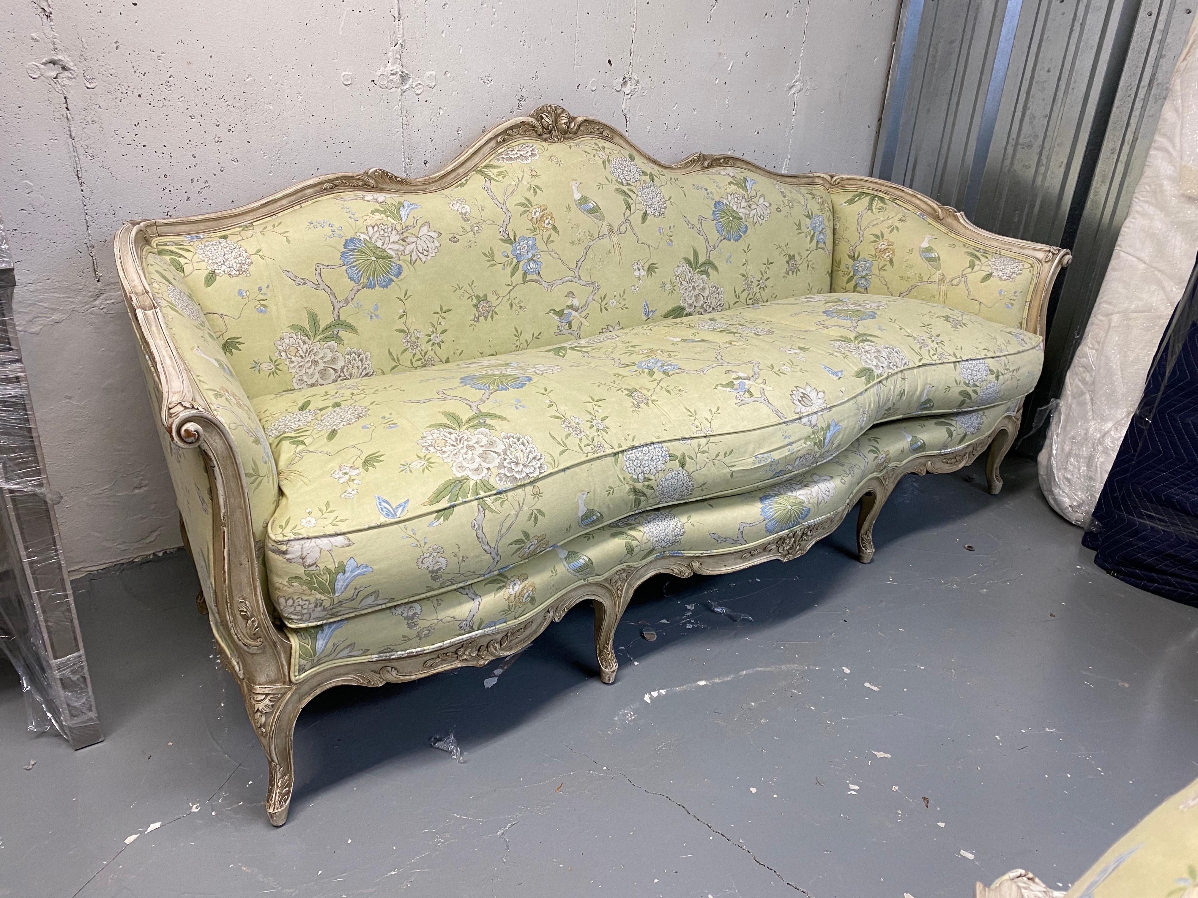 20th Century Louis XV Style Upholstered Sofa
A French Louis XV style white washed wood frame sofa upholstered in a bright green-yellow cotton chinoiserie fabric. Front of sofa in a lovely curved serpentine shape. 
Some light wear on finish on legs.
