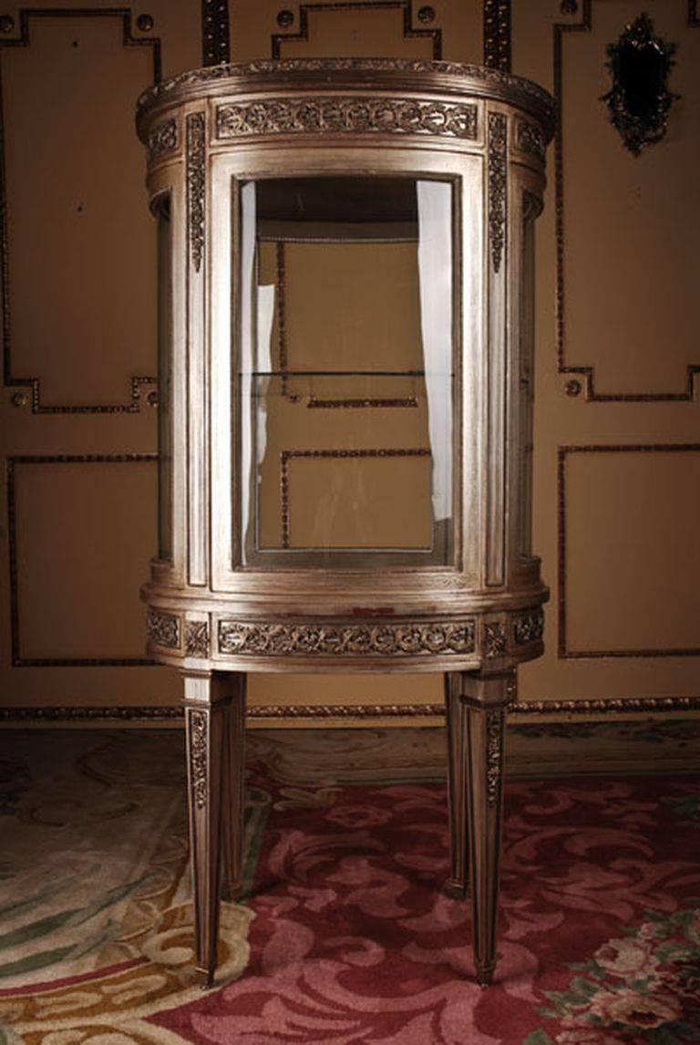 French salon vitrine in Louis XVI classicist style
Solid beechwood colored hand-painted. Oval one-drawered combered and four-sided glassed body on high, brass-painted four edged legs, ending in Sabots. Border and cornicing with finely engraved