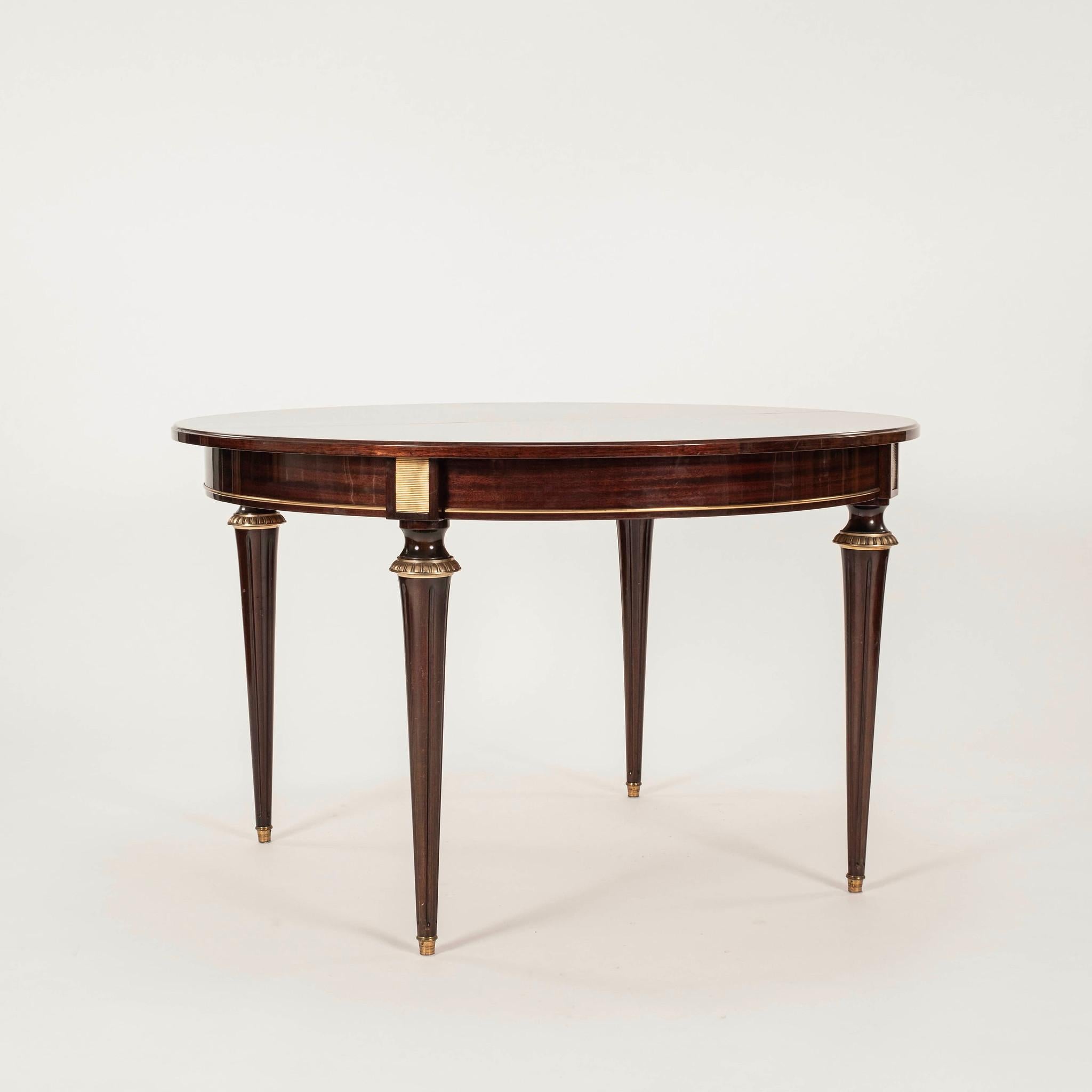 Table de salle à manger italienne du 20e siècle de style Louis XVI, avec un beau plateau d'allumettes laqué, des détails en bronze doré et des sabots. Il manque une feuille à la table, mais le joint central est bien serré.