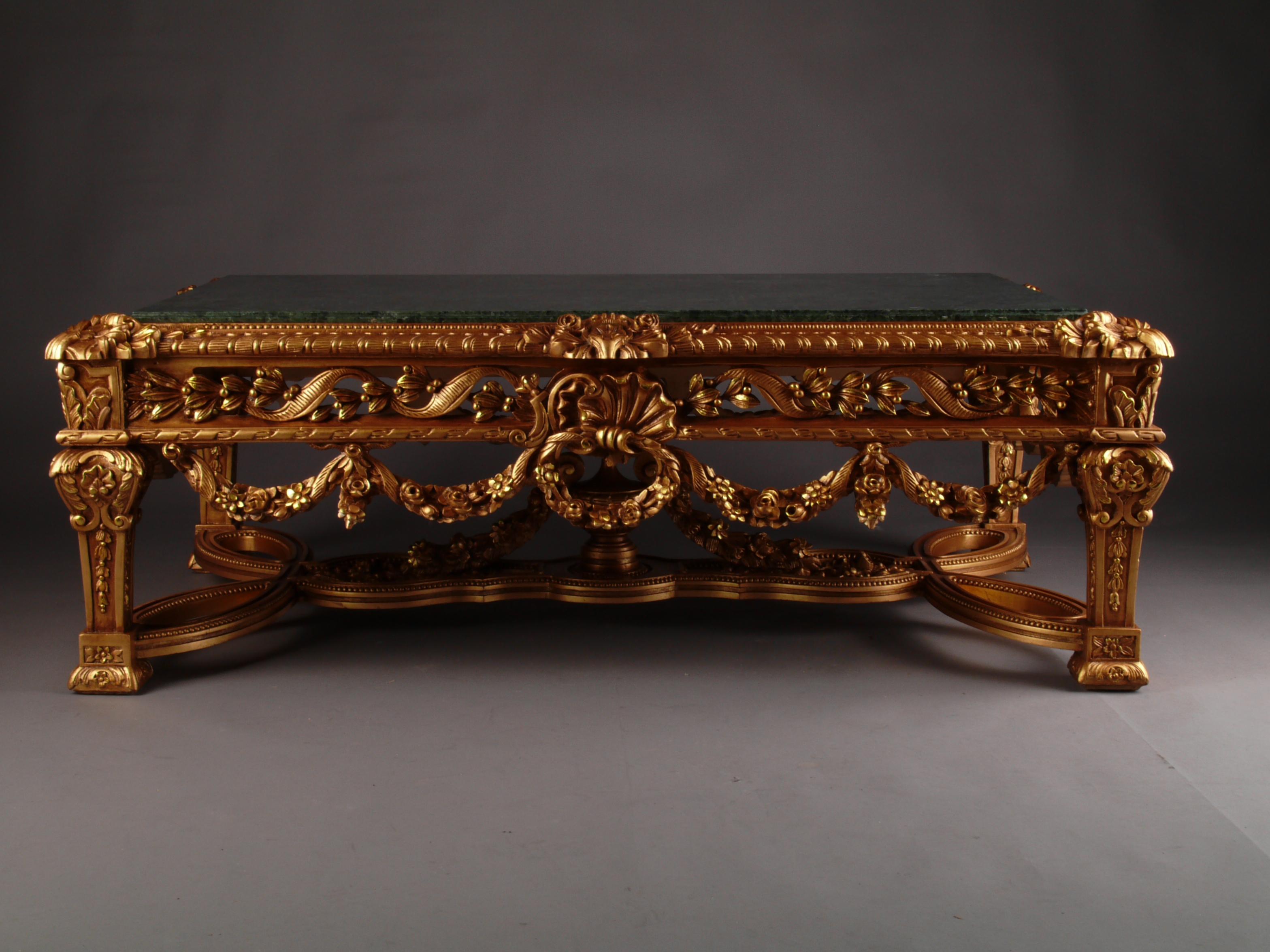 Monumental pomp salon table in Louis XVI style.
Highly valuable solid beechwood carved in finest detail. Colored hand-painted and gilded. On conical legs, connected with X- formed strong carved wood middle bars .With garland ornamented frame-base.
