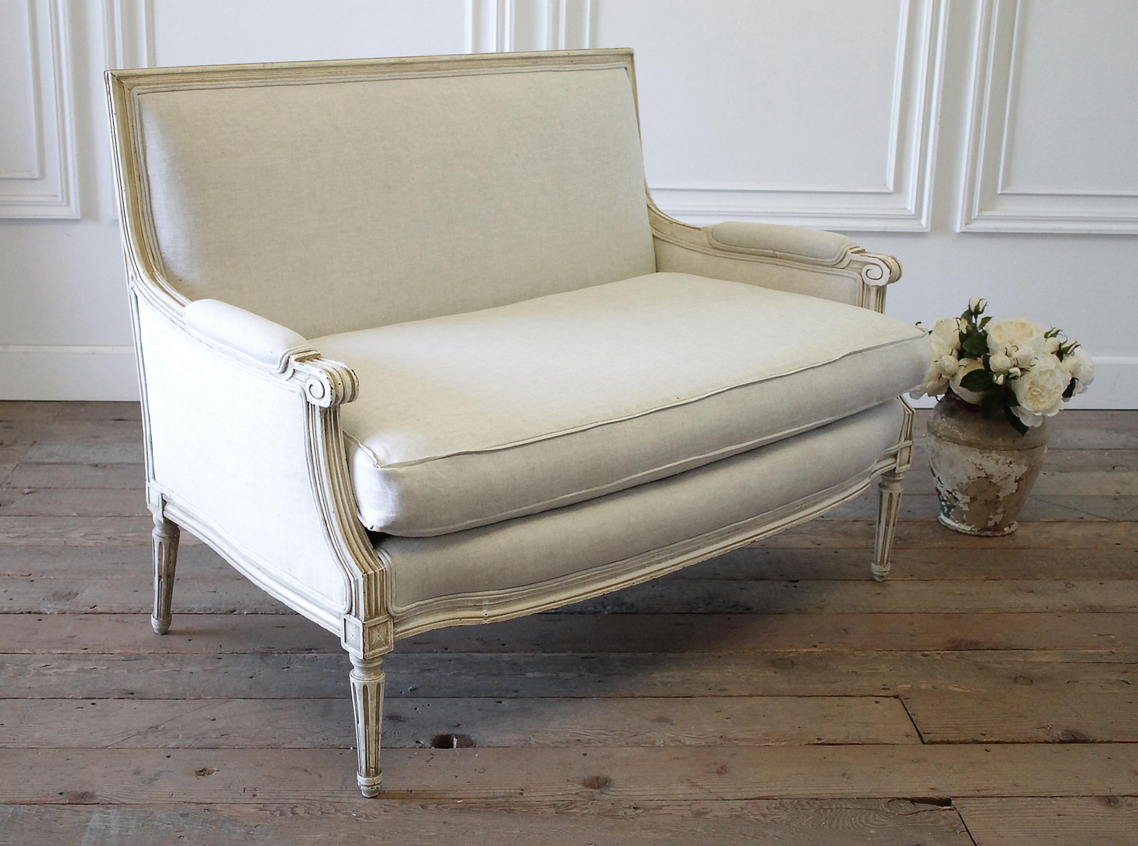 20th century Louis XVI style upholstered linen settee
Original painted finish in a natural and creamy white color, with beautiful patina slightly faded paint with subtle distressed edges. We reupholstered this settee in a thick Belgian linen, a
