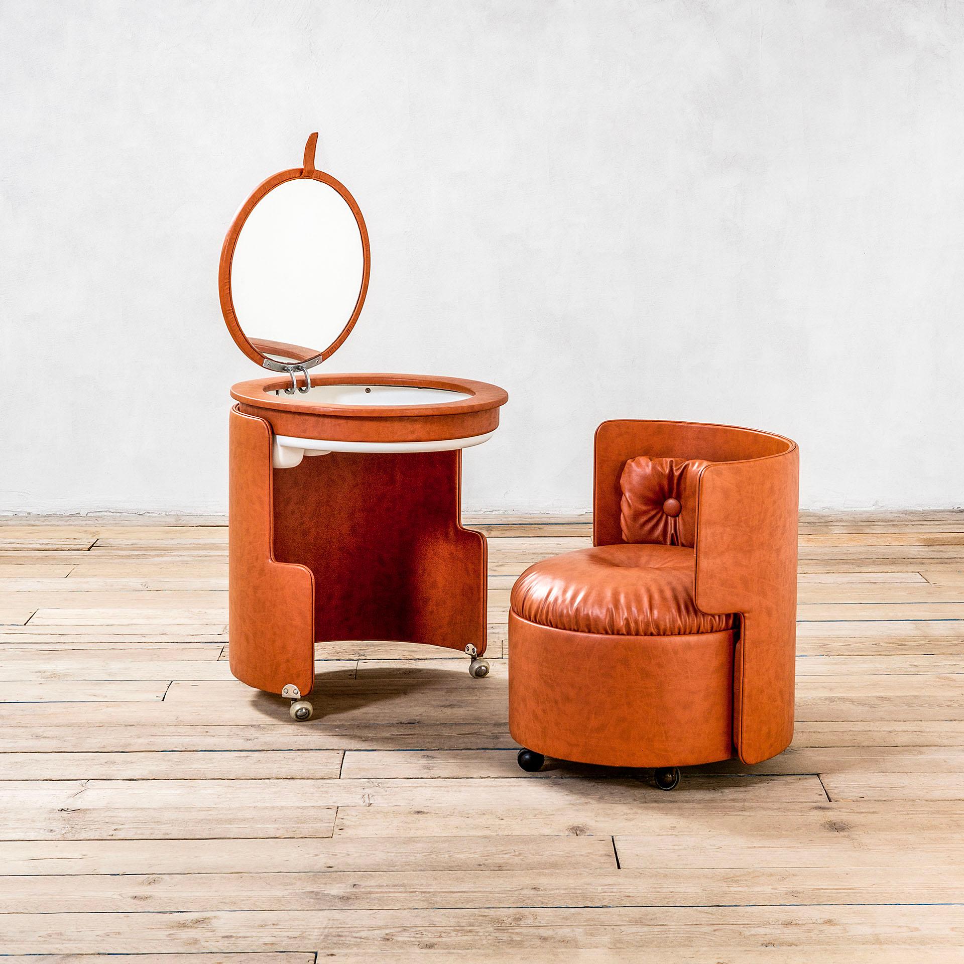 Dressing table model Dilly Dally designed by Luigi Massoni for Poltrona Frau in 1960s. The dressing table is composed of two pieces, one round armchair (which alone measures 70 x 65 x 60 cm) and the table itself with space for accessories and a