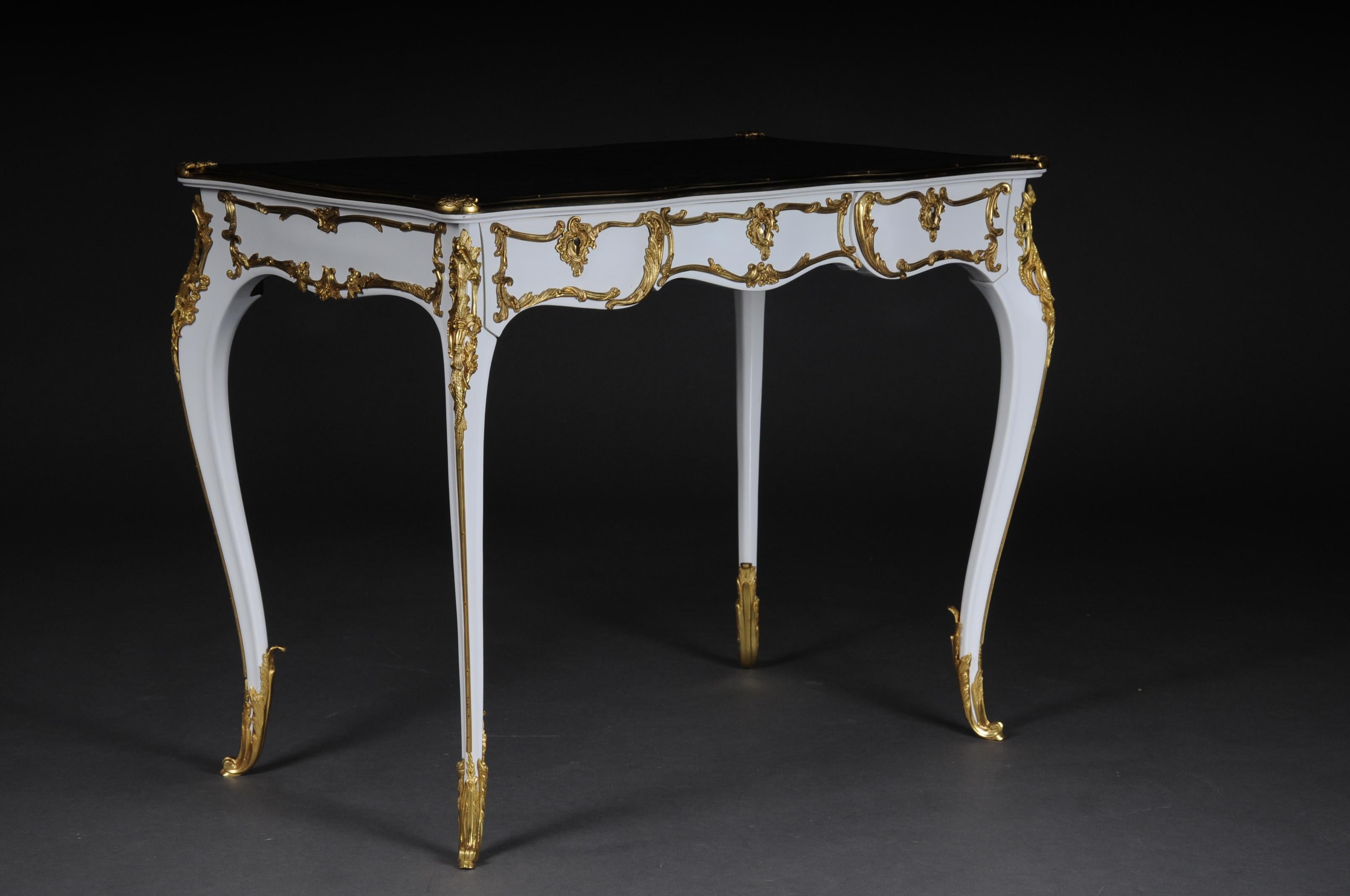 20th century luxurious white bureau plat / writing desk in Louis XV style

Solid beechwood colored in white. Very fine, floral bronze fittings.
Curved and pronounced / arched wooden body. Frame base with four-sided curvature.
3 drawers and wide