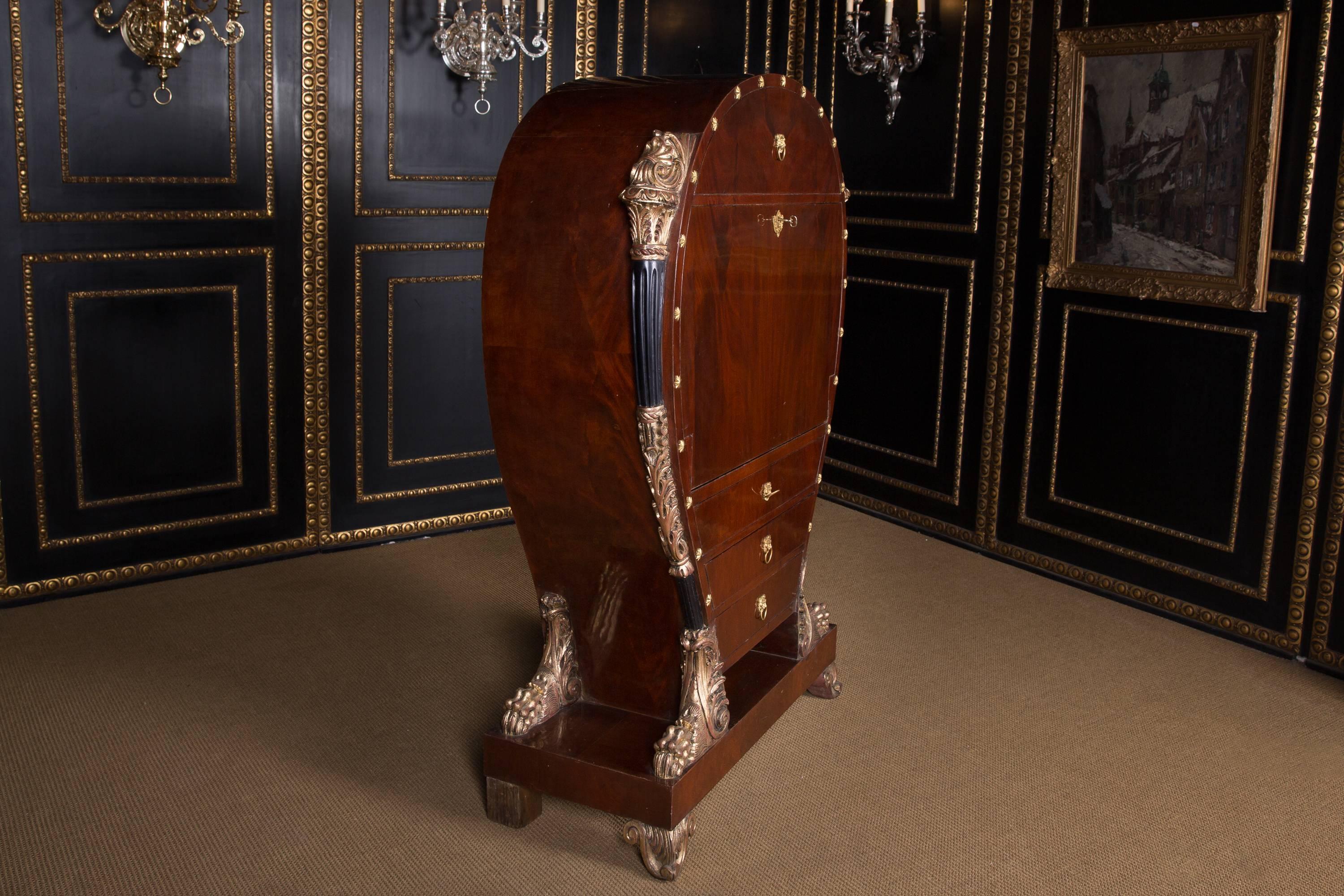 Acajou sur conifères massifs. Sur présentation du grand maître viennois du meuble Franz Dettler. Des cornes de remplissage en bois sculpté et des étoiles en bronze encadrent le corps du meuble en forme de lyre. Mascara lion en plastique avec anneaux