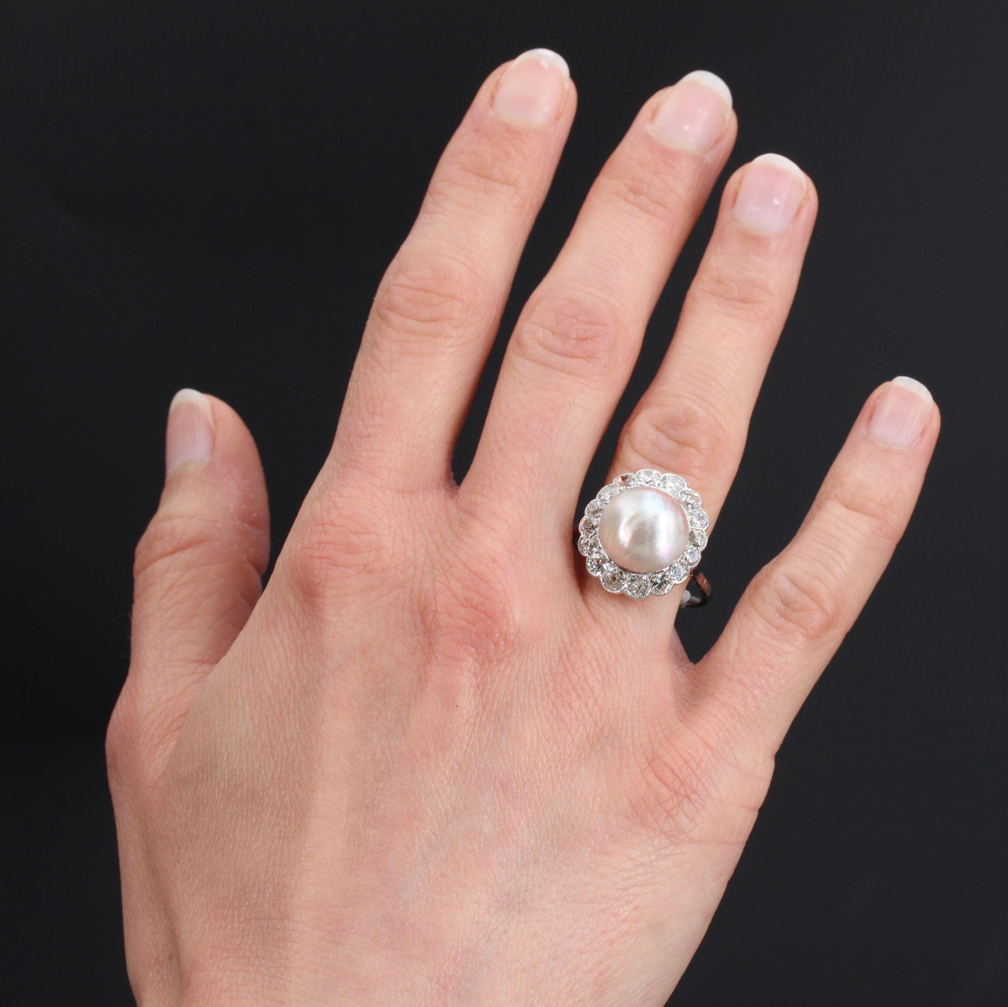 Ring in 18 karat white gold, owl hallmark.
Sublime and important antique ring, it is adorned with a mabe pearl with iridescent white-pink orient, in a setting of antique cushion-cut diamonds. The setting is beautifully openworked.
Diameter of the