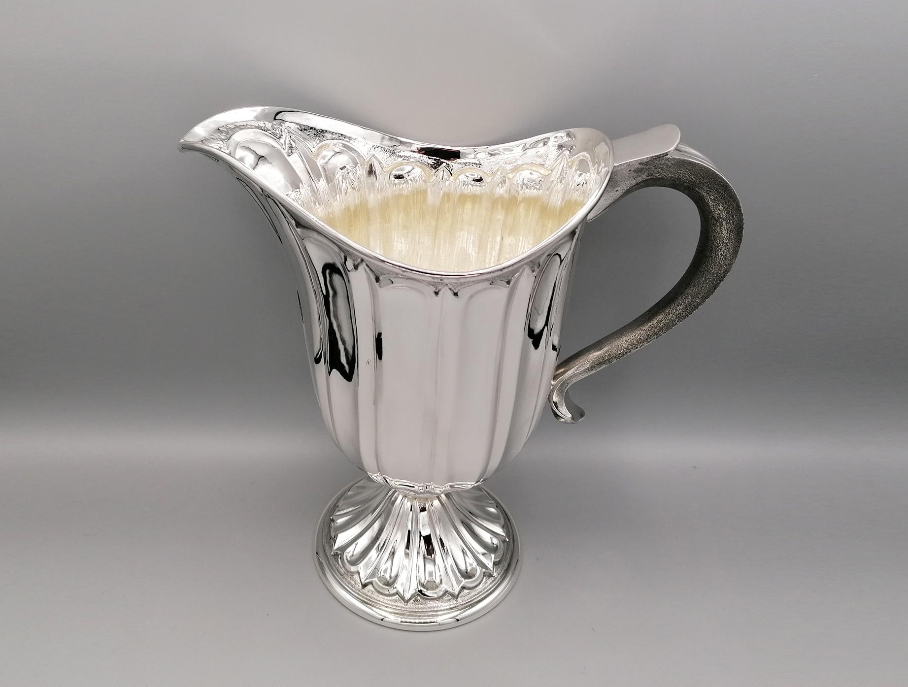 Fully handmade medieval style solid sterling silver jug. The body is oval and shaped embossed grooves. The base, separated from the rest of the body by a bushing, is round with the same design.
The handle has been worked in checkering on the inside